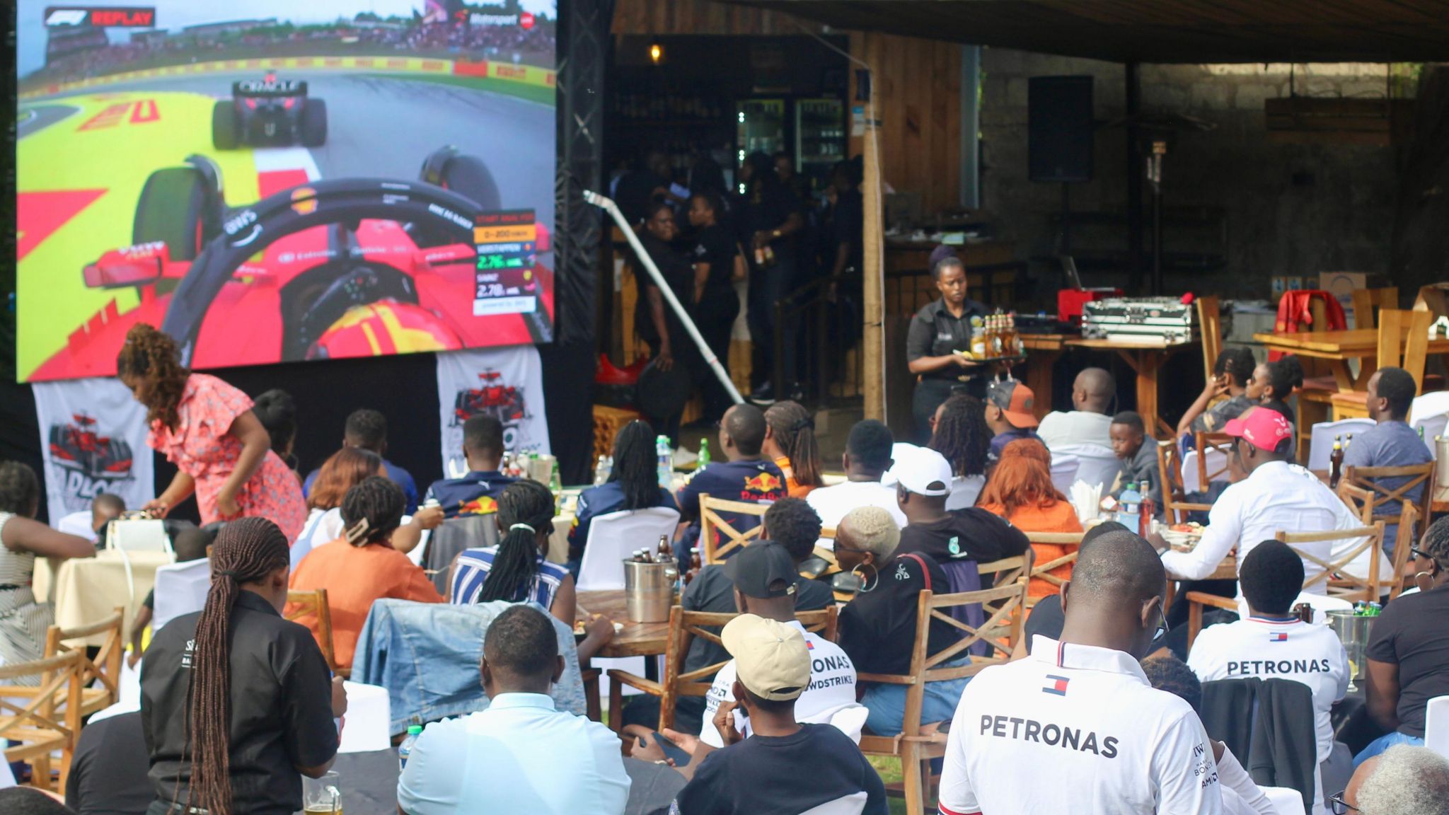 Members of Paddock Experience, a Formula 1 club in Kenya, watching a race at an entertainment spot in Nairobi