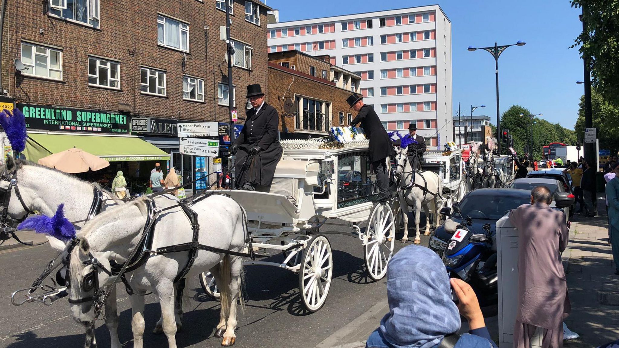 Horse drawn carriages leading funeral service