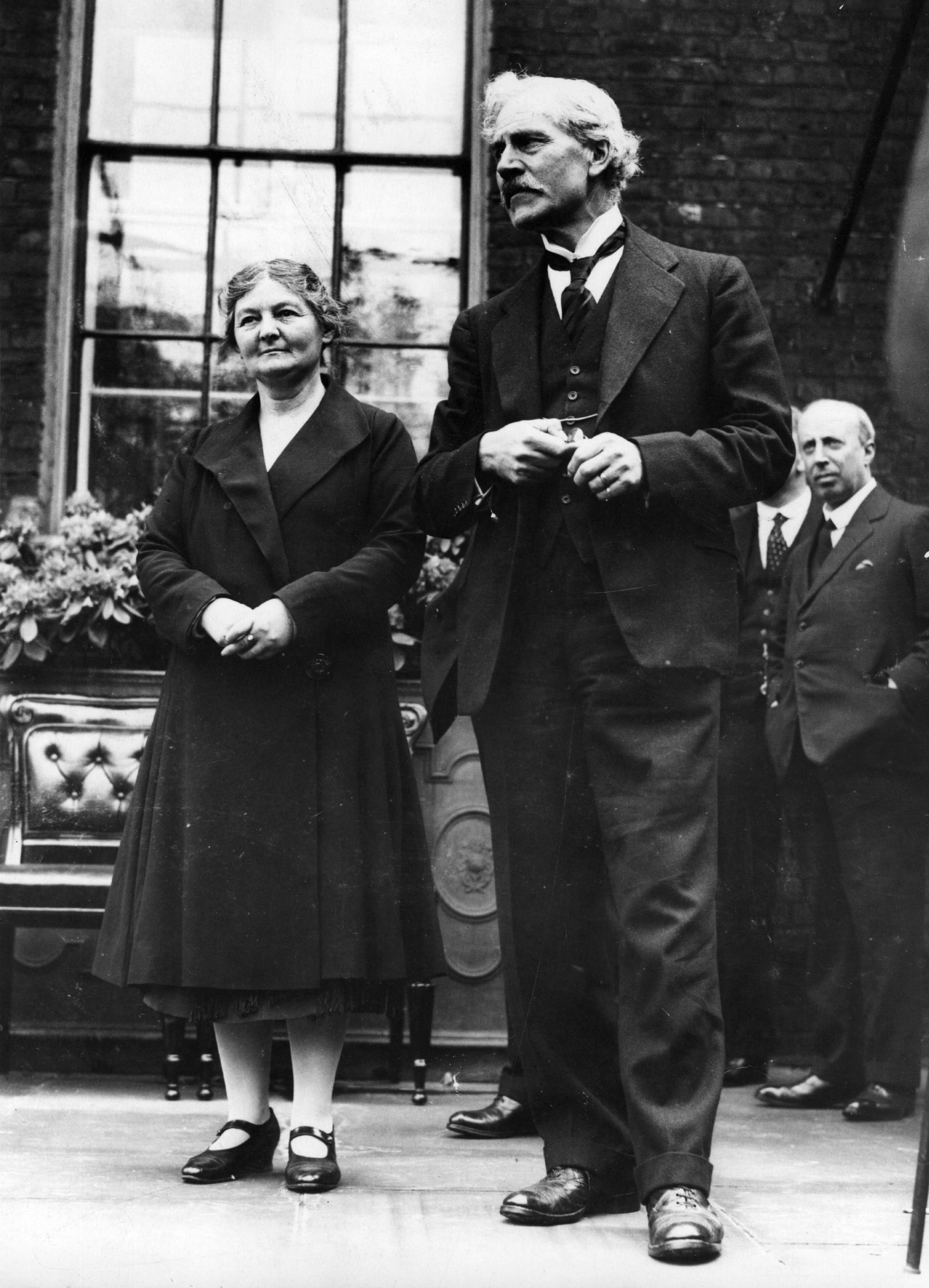 Black and white photograph of Margaret Bondfield stood smiling next to Prime Minister Ramsay MacDonald