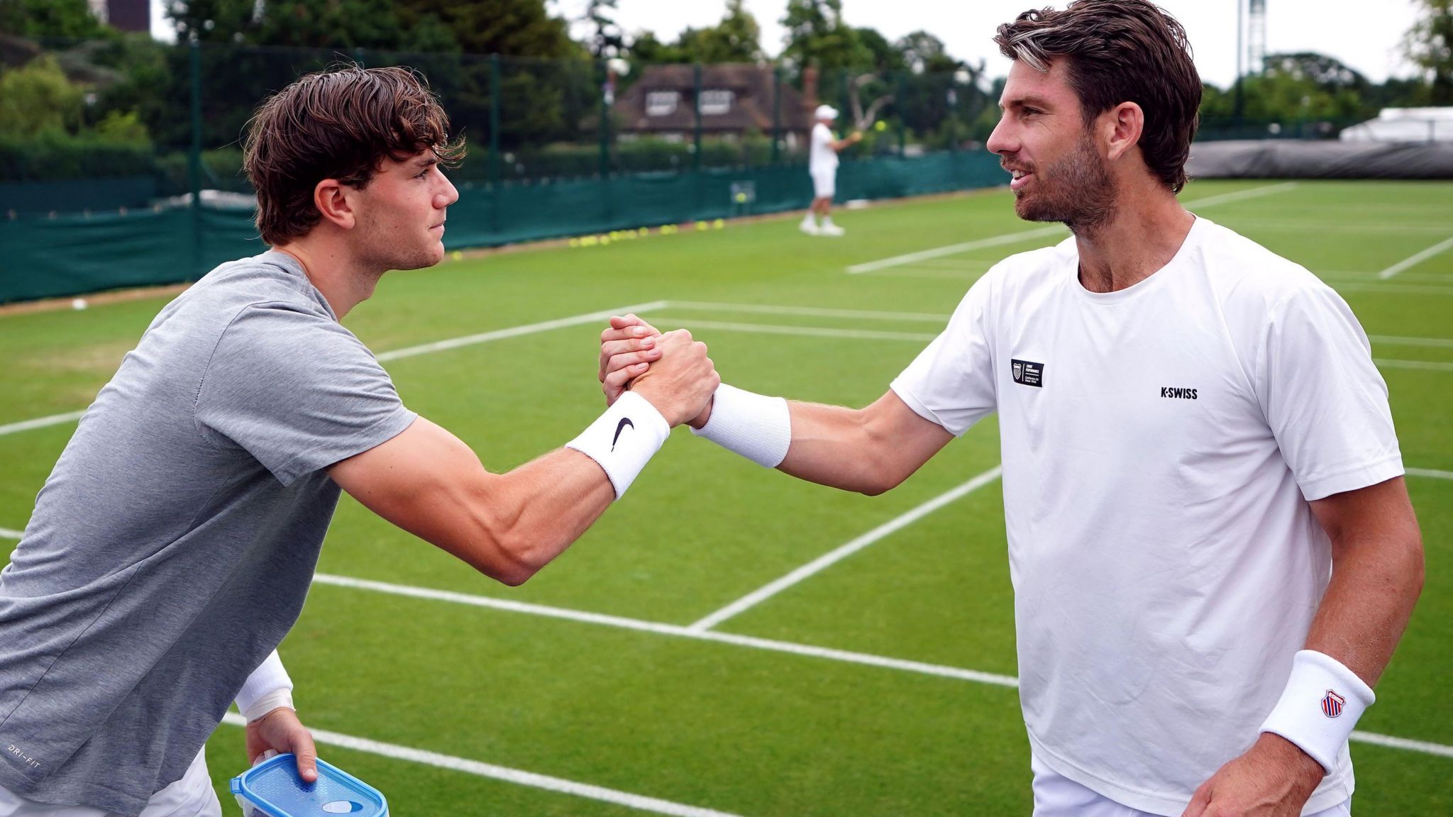 Jack Draper and Cameron Norrie clasp hands as they greet each other at Wimbledon