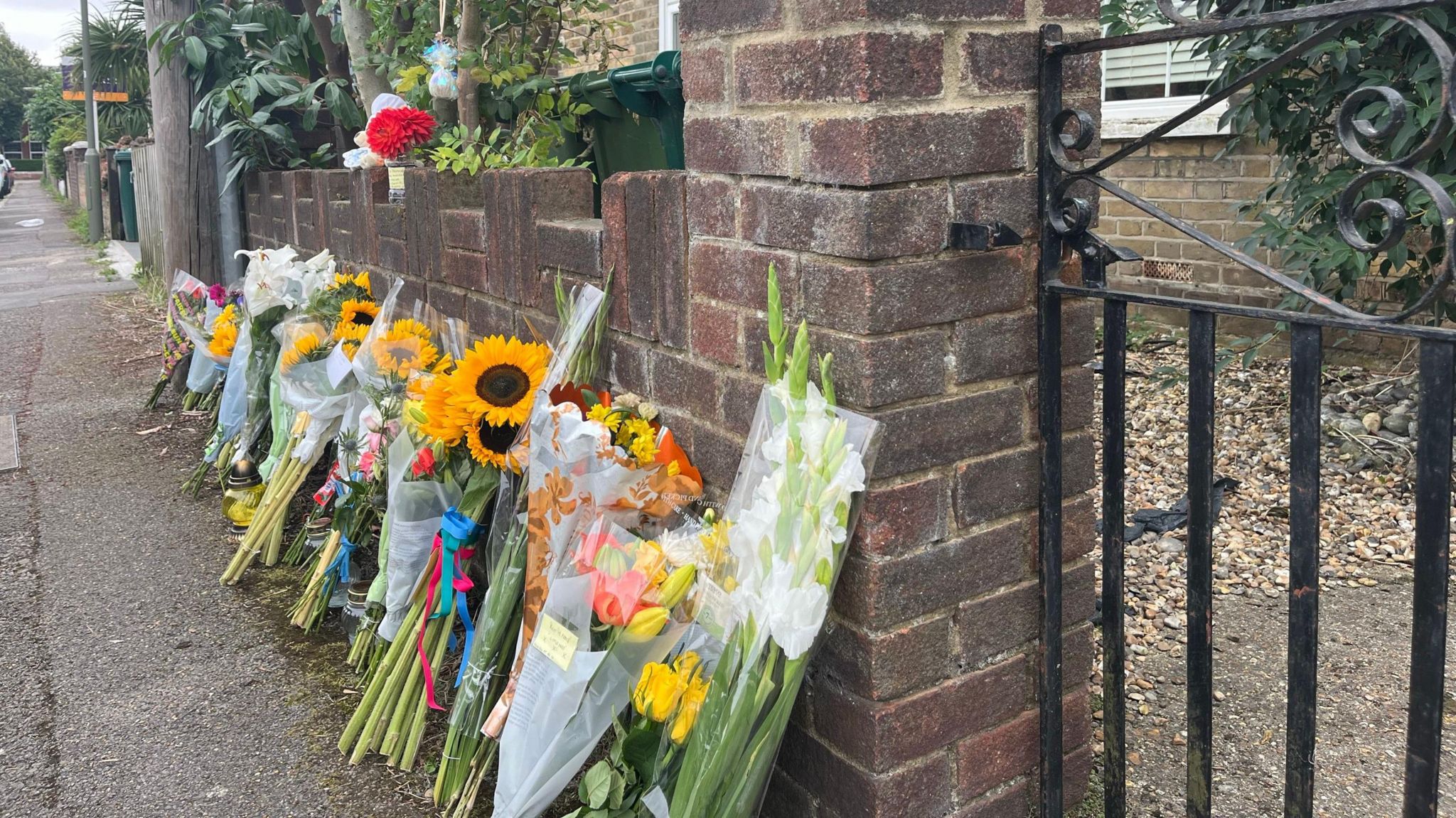 Flowers outside the house where the bodies of a man and three children were found on Saturday