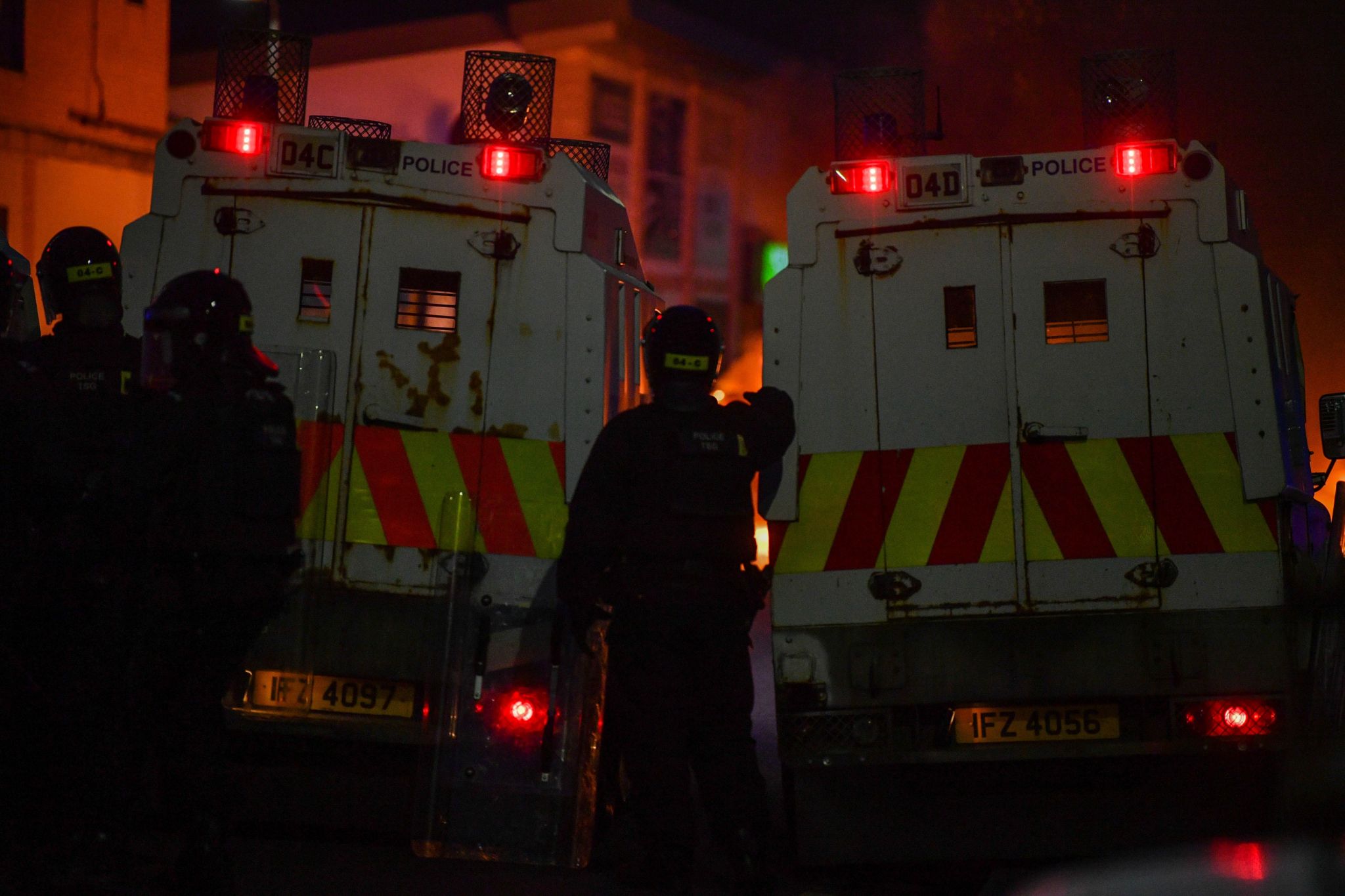 Police in riot gear behind landrovers