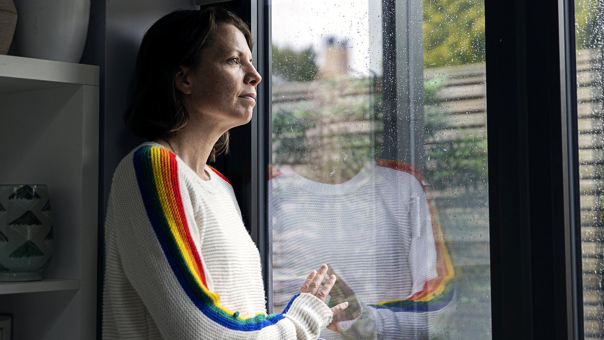 A woman looks through a window