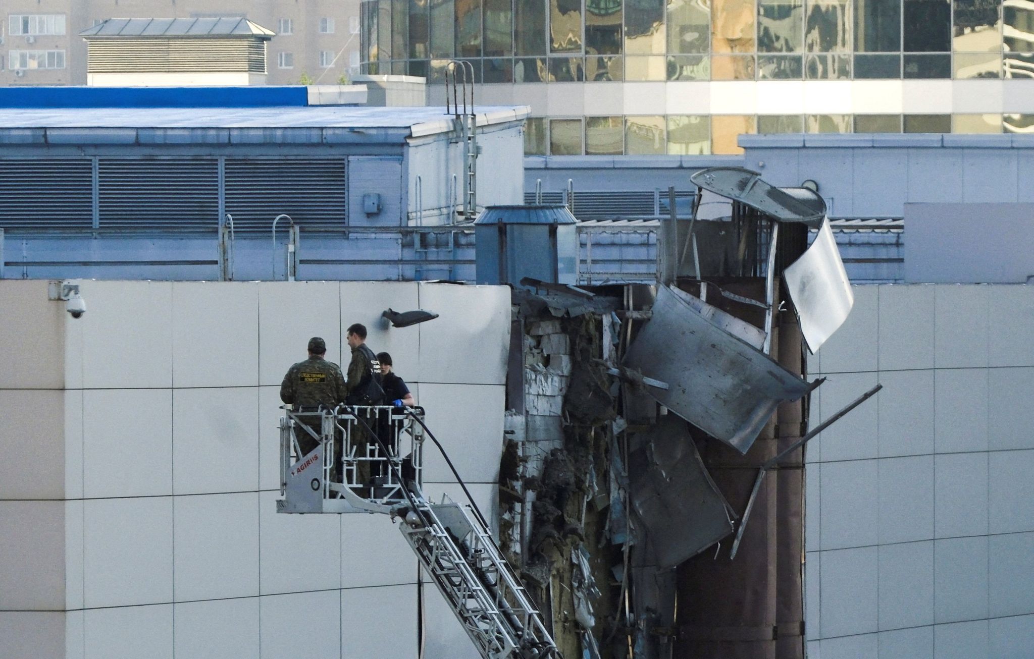 A picture of three officials examining the damage on the external wall of the Moscow's Expo Centre which was hit on 18 August by a suspected Ukrainian drone attack.