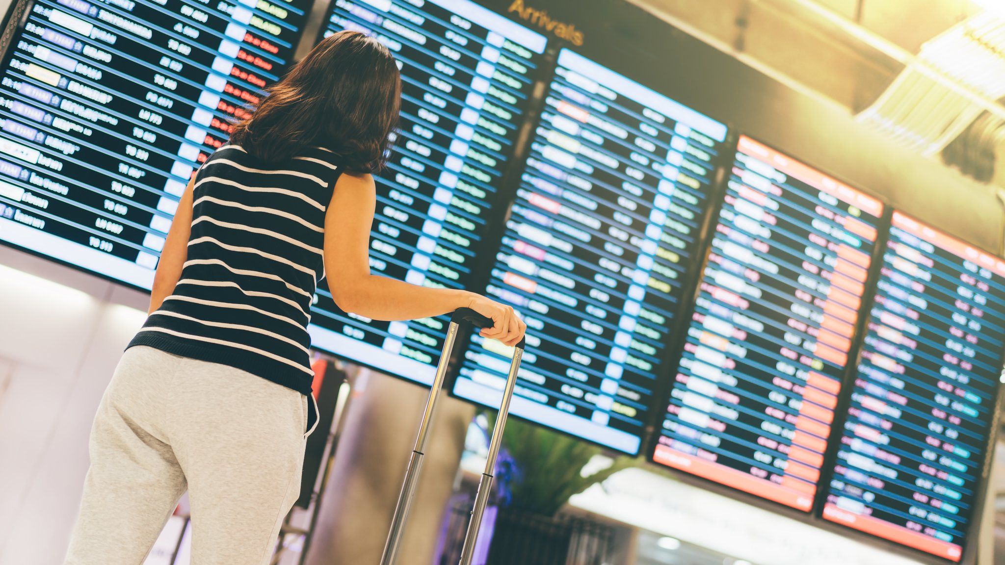 Woman standing in front of departure board