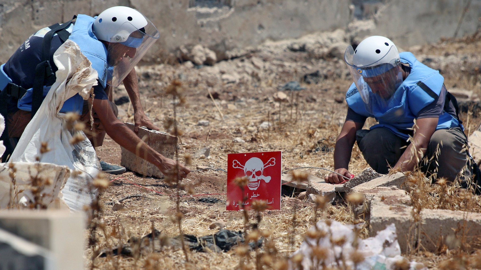 Civil defence members prepare to safely detonate cluster bombs in a rebel-held area in Deraa, Syria (26 July 2017)