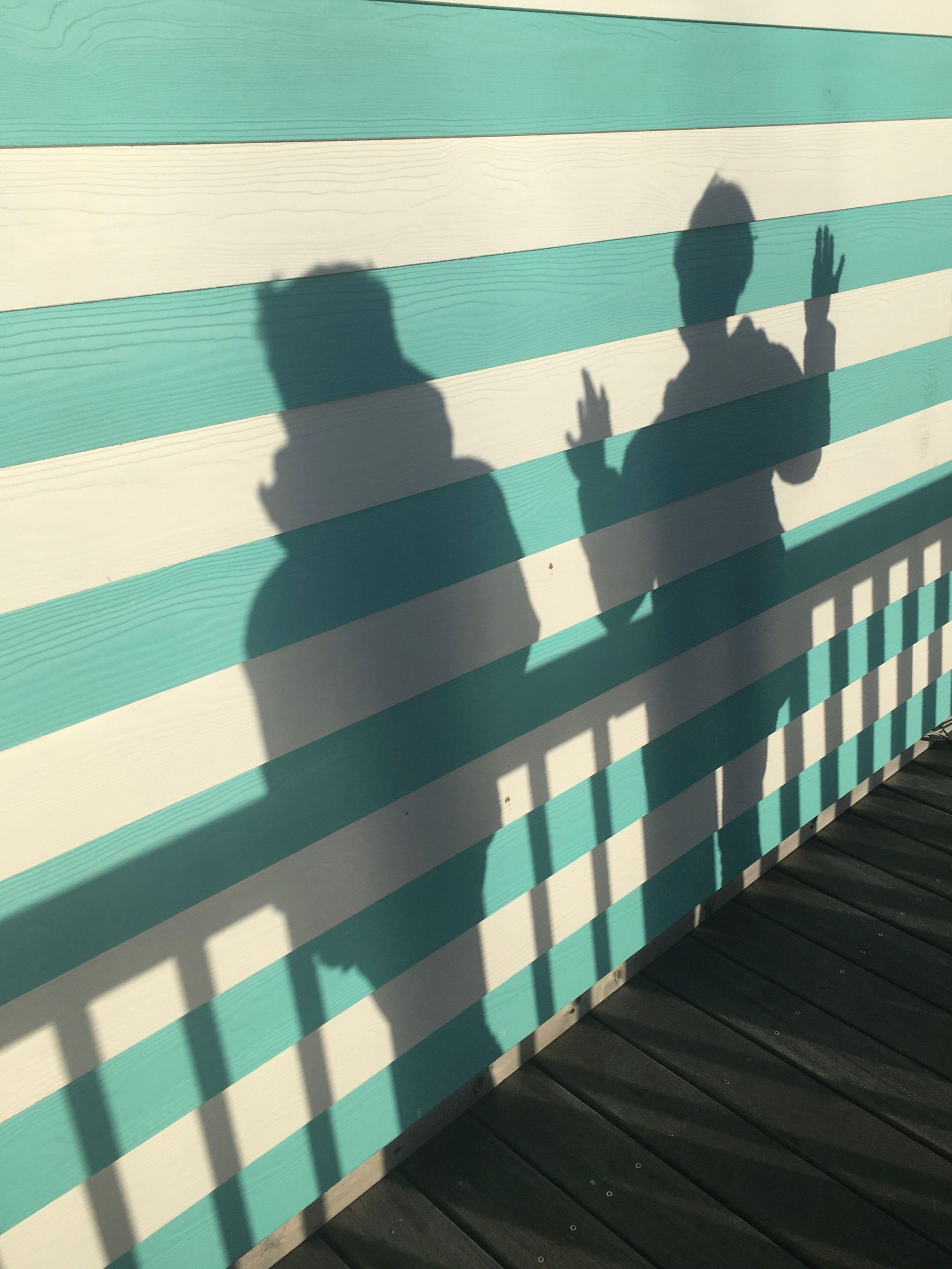 The shadows of two people on a striped wall