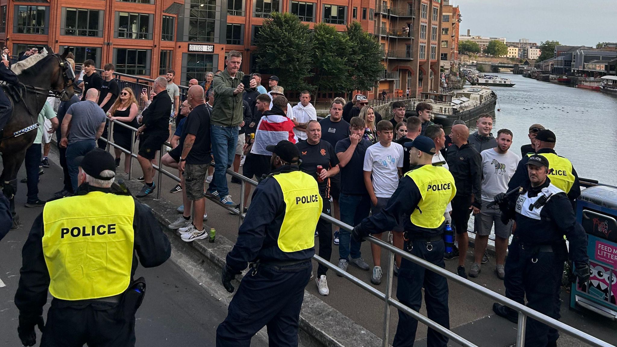 Police and protesters standing on a bridge