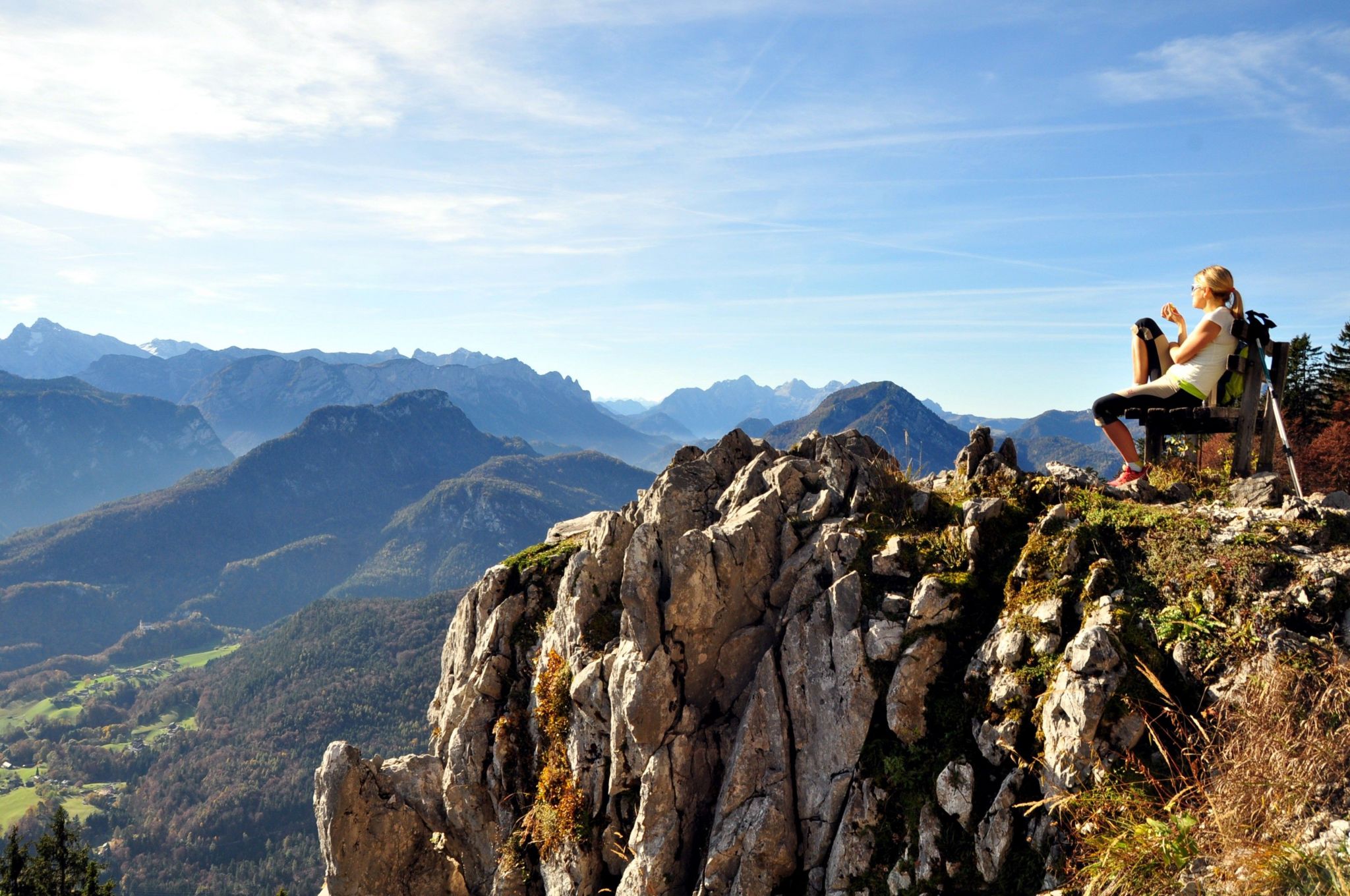 A woman relaxes and enjoys the view on top of a mountain