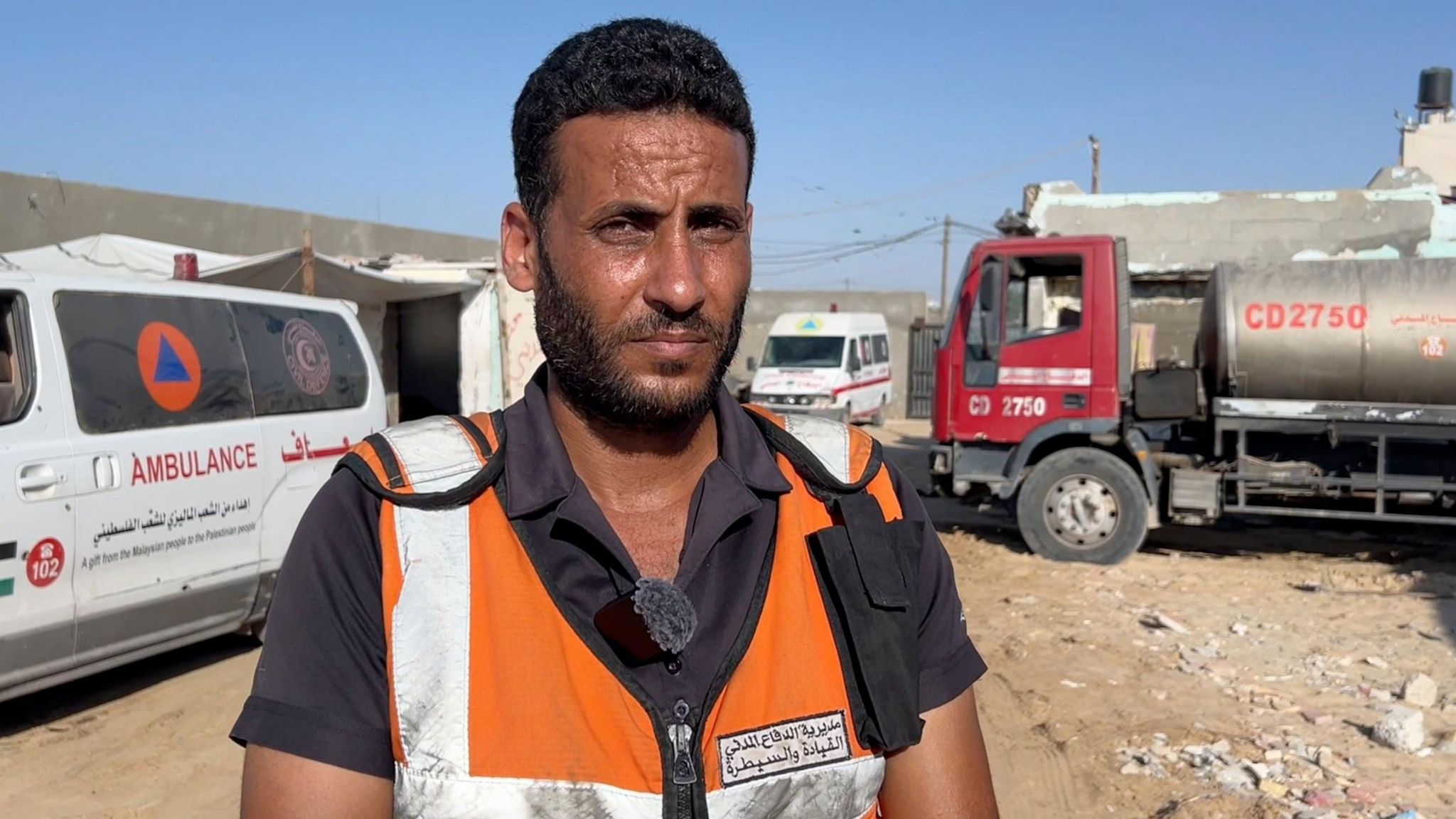 Muhammed Al Mughayer, a Gaza Civil Defence official, stands in front of an ambulance