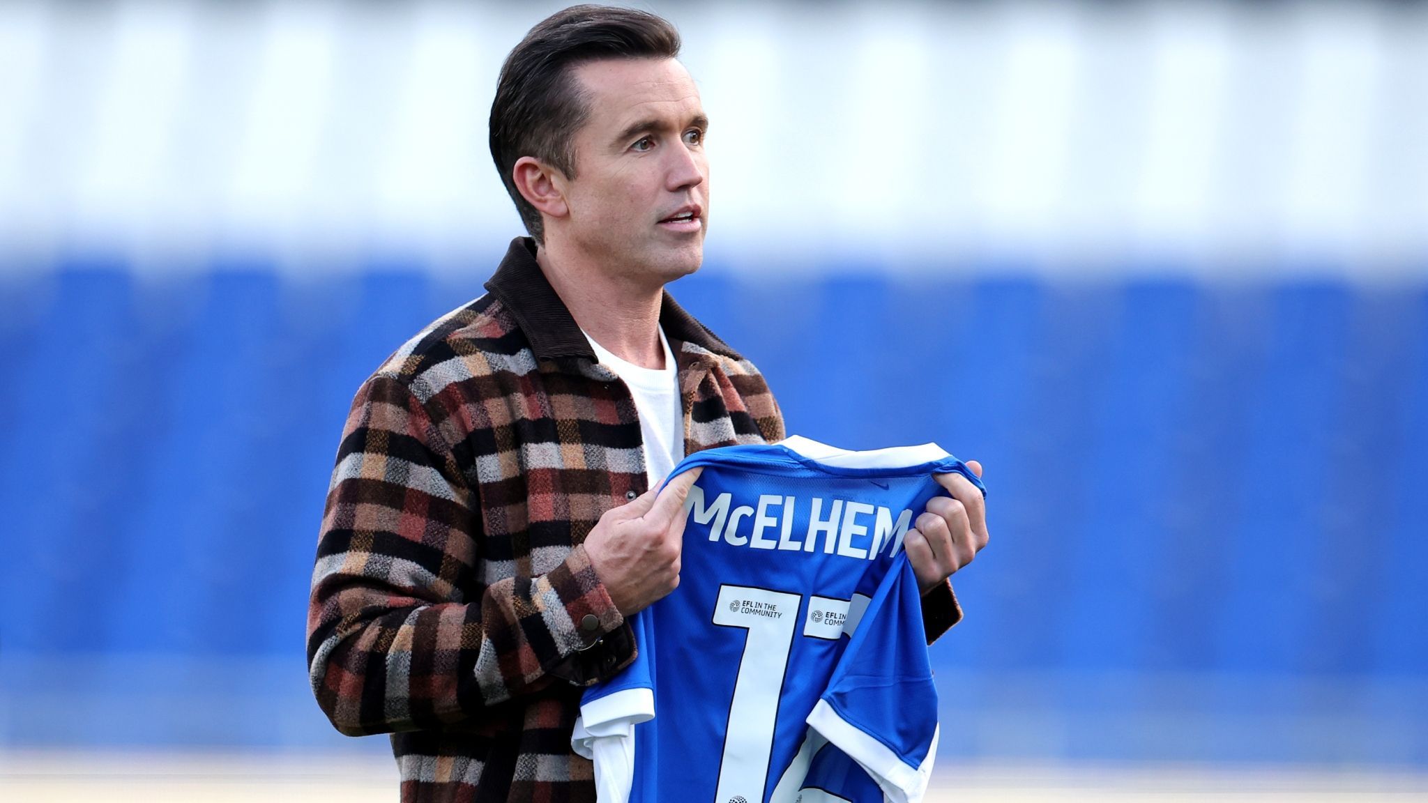 Rob McElhenney, co-Owner of Wrexham AFC, holding a Birmingham City shirt featuring the name "McElhenney" and the number 12 prior to the League One matchat Birmingham City FC 