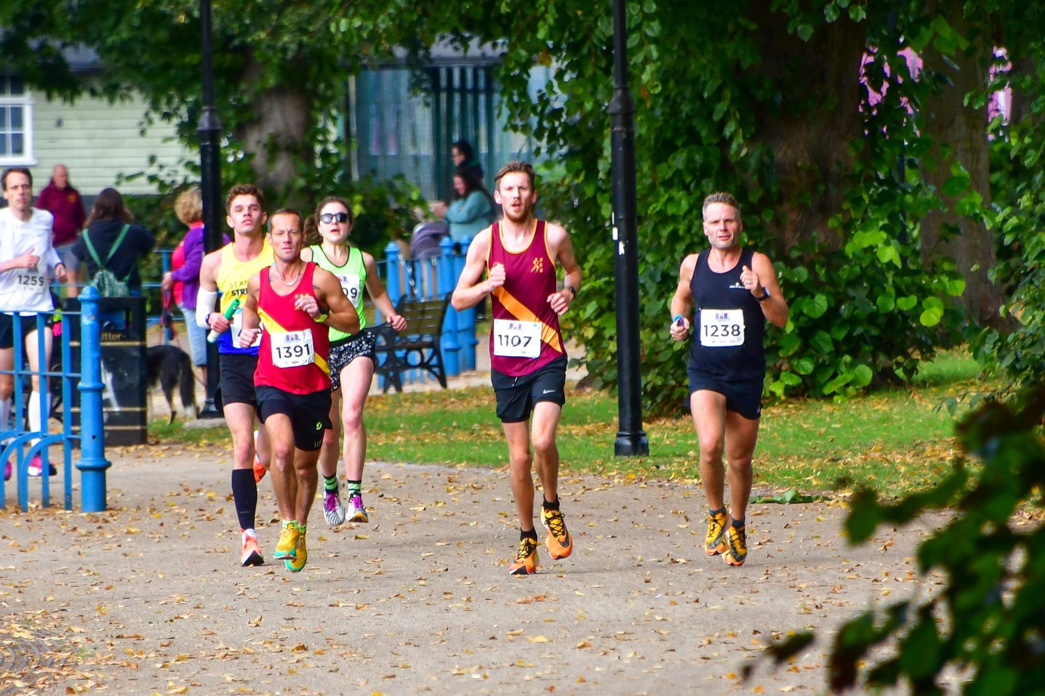 Entrants to the 2021 half-marathon running through a park
