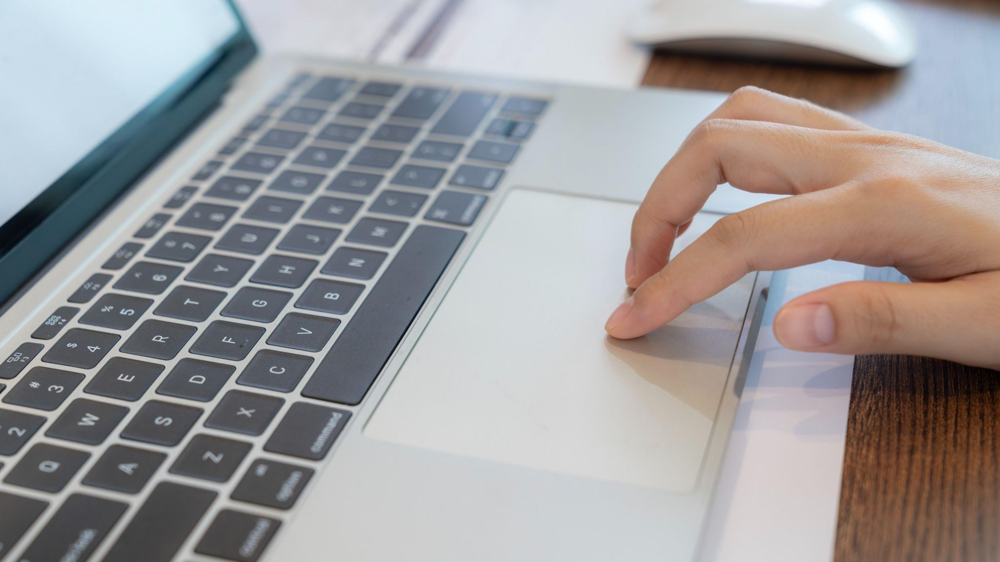 Someone typing on the keyboard of a laptop.