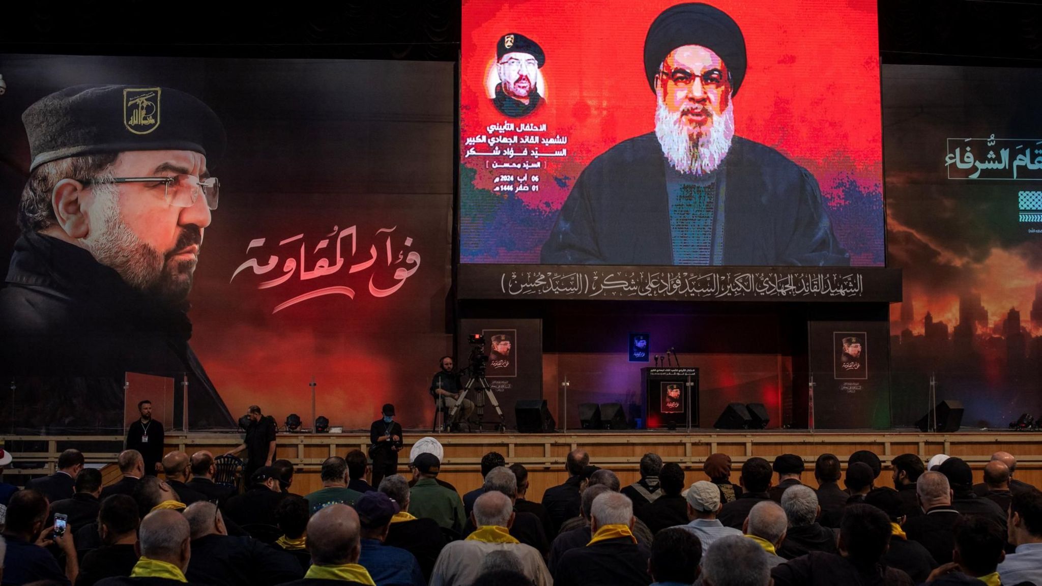 Hezbollah supporters listen to a speech by the group's leader Hassan Nasrallah (right), at a memorial ceremony for senior commander Fuad Shukr (left), after the latter was killed in an Israeli strike (6 August 2024)