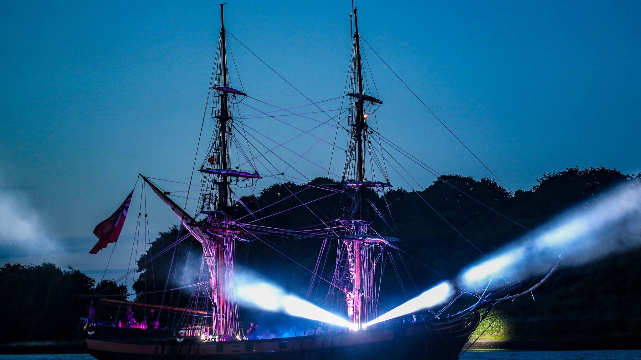 An illuminated tall ship sails at night up the river foyle to mark end of the maritime festival
