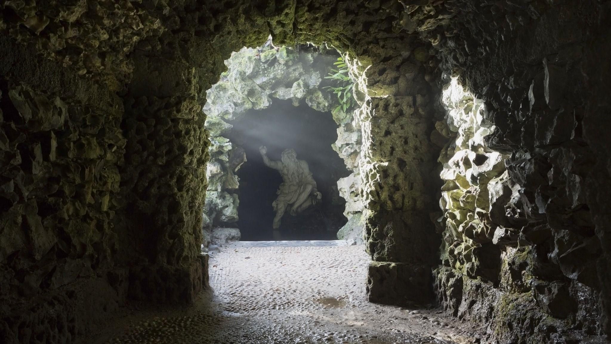 Dark image of a grotto full of stone and giant statue