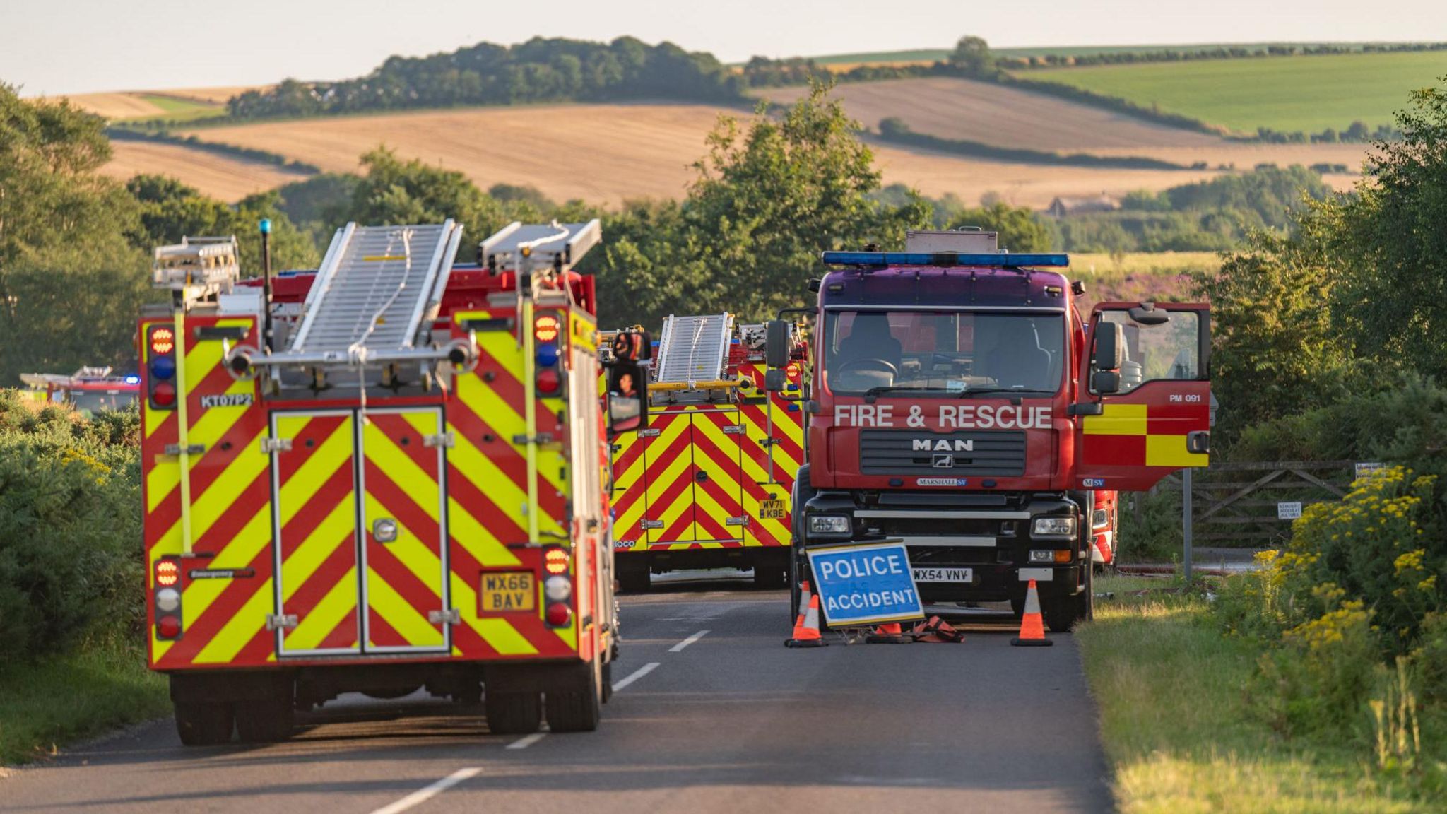 Three fire engines parked on a rural road