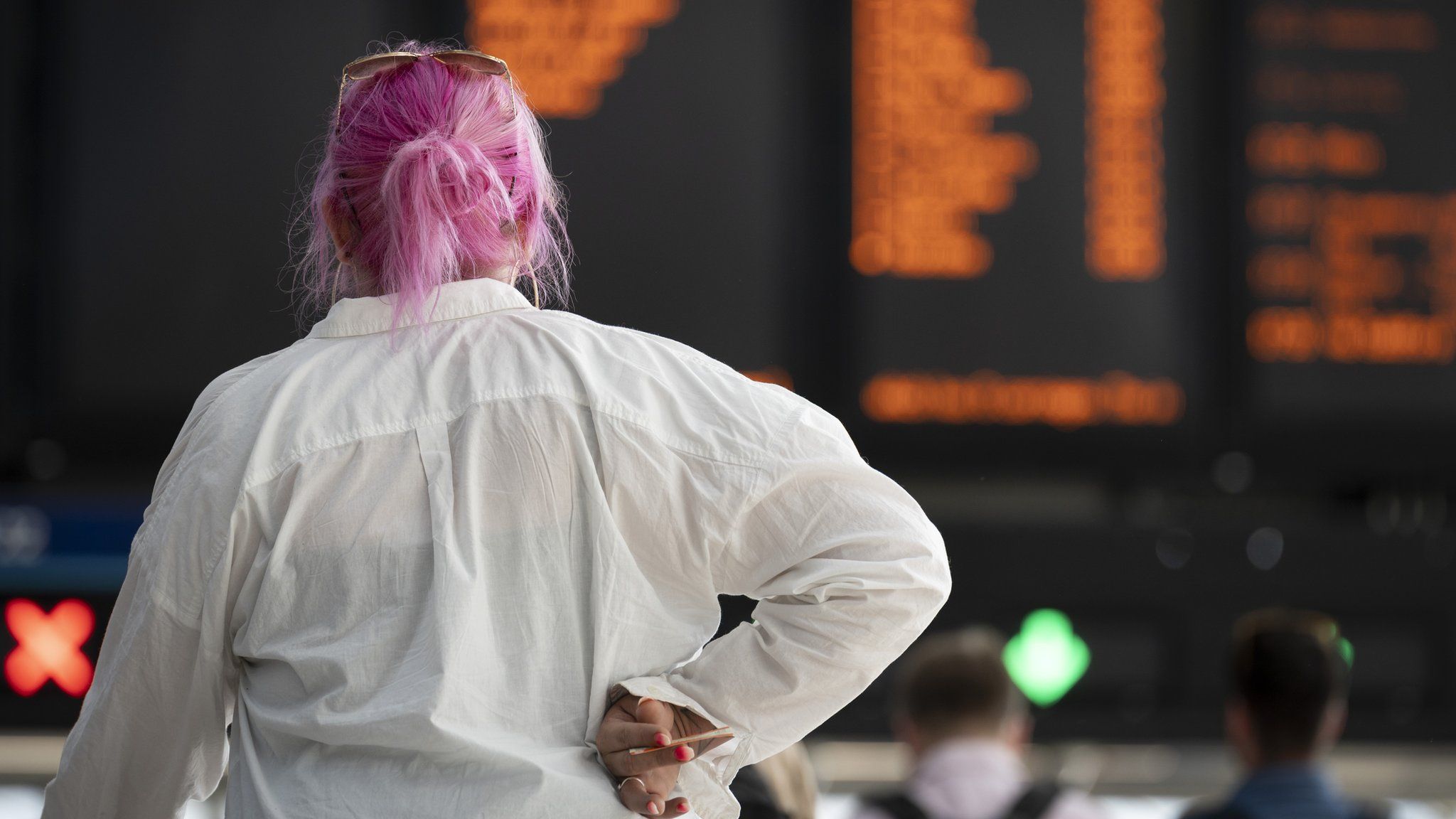 Woman looks at rail departures board