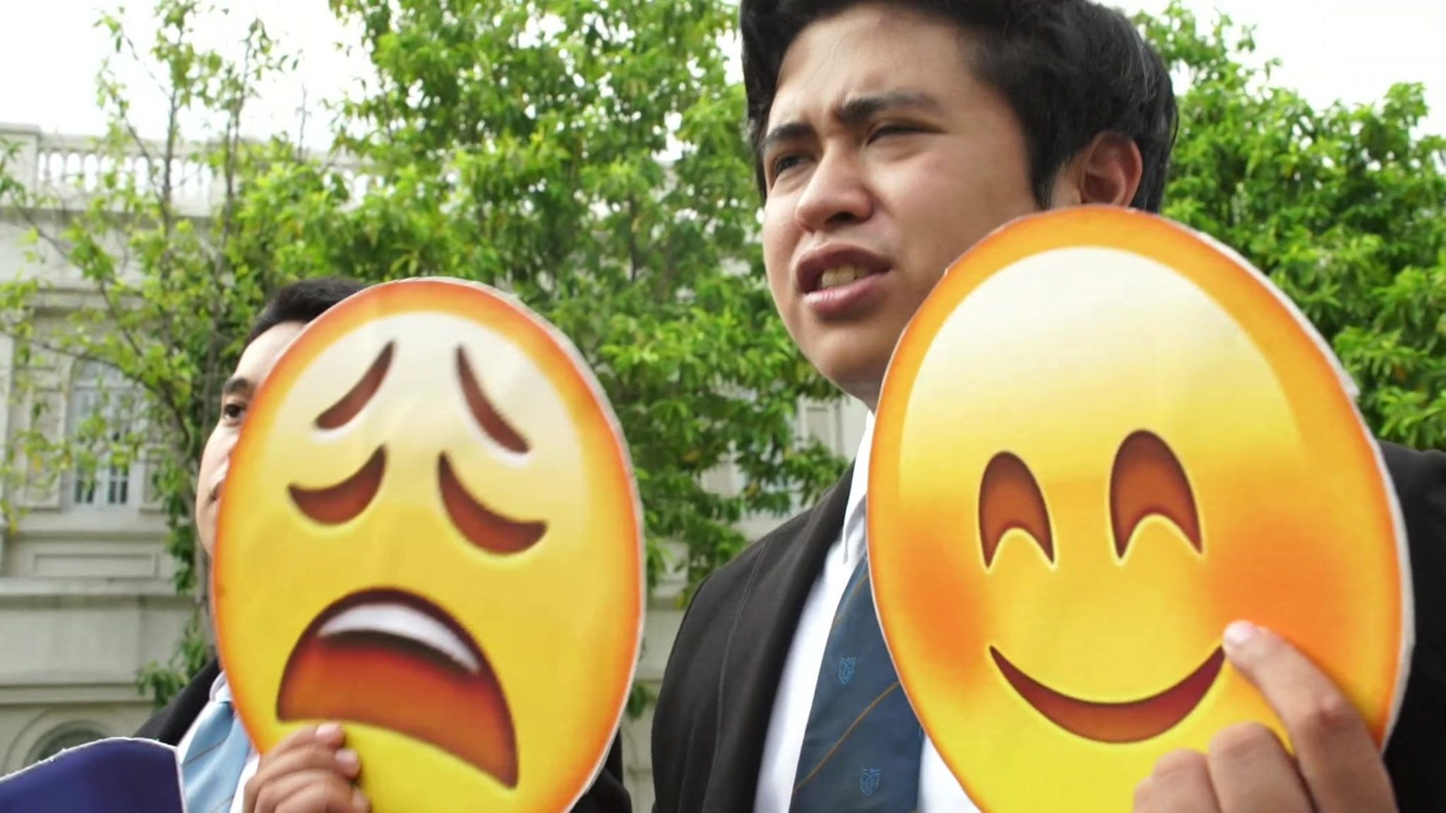 Filipino student holds up emojis