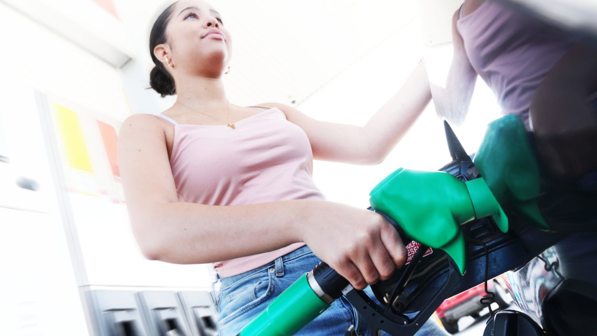 Woman filling up car at petrol pump