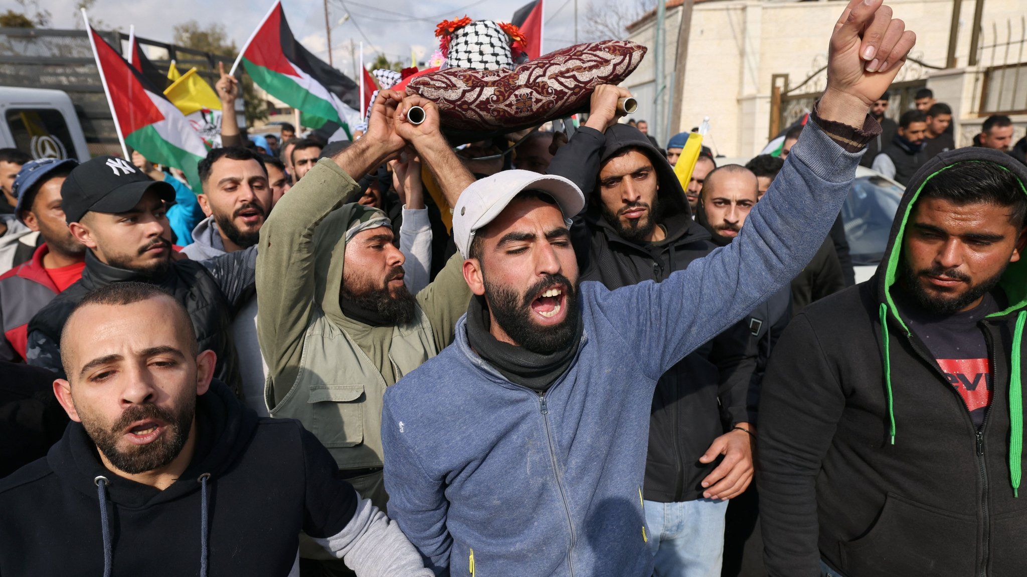 Palestinian mourners carry the body of Ahmad Kahla during his funeral in the village of Rammun, in the occupied West Bank, on 15 January 2023