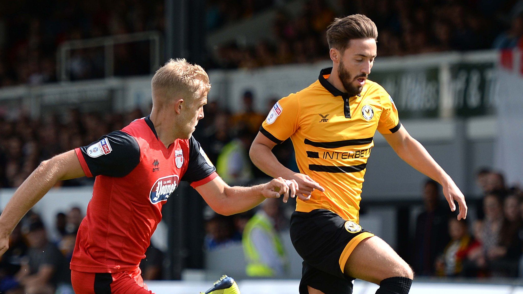 Josh Sheehan of Newport County is tackled by Harry Davis of Grimsby Town