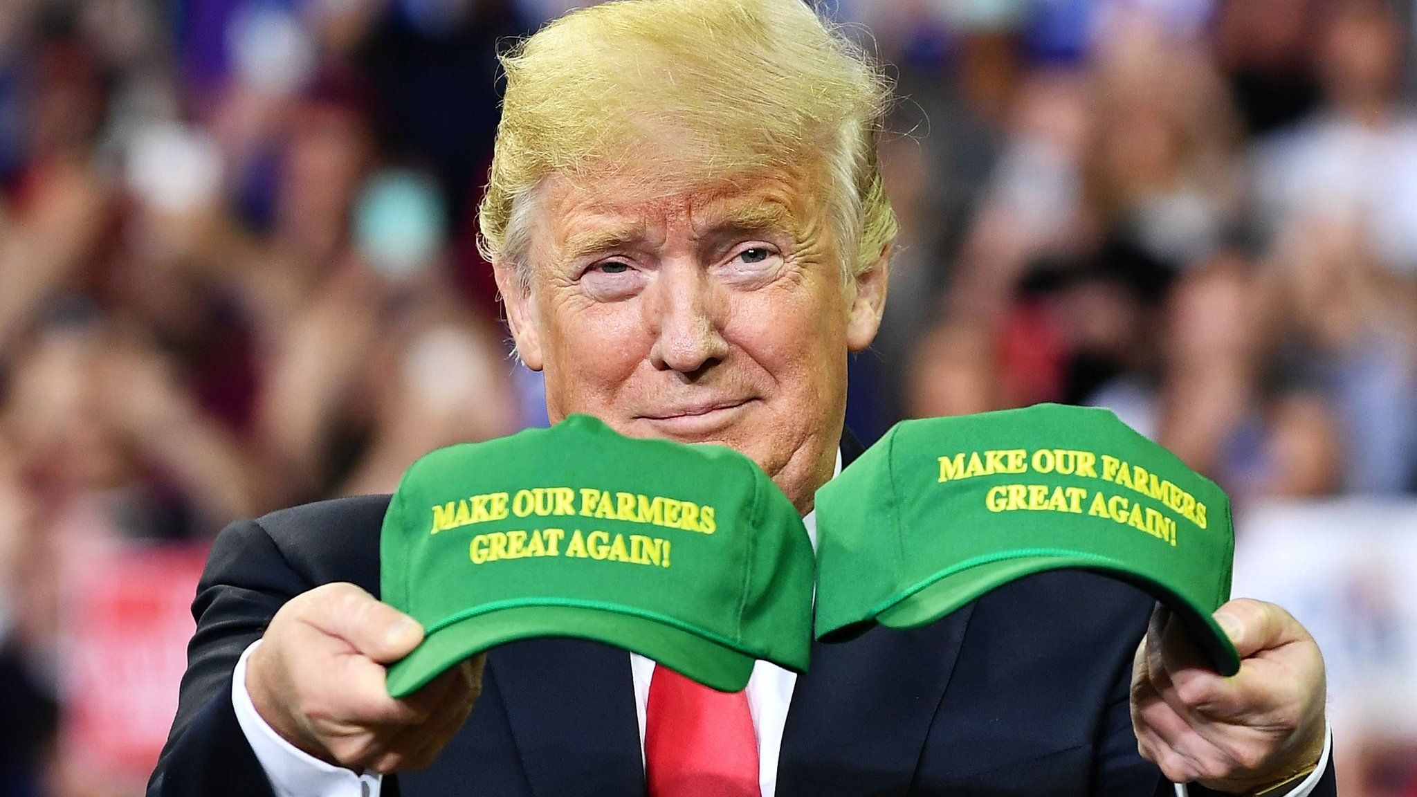 US President Donald Trump displays hats that read: "Make Our Farmers Great Again!" at a campaign rally at Ford Center in Evansville, Indiana on August 30, 2018