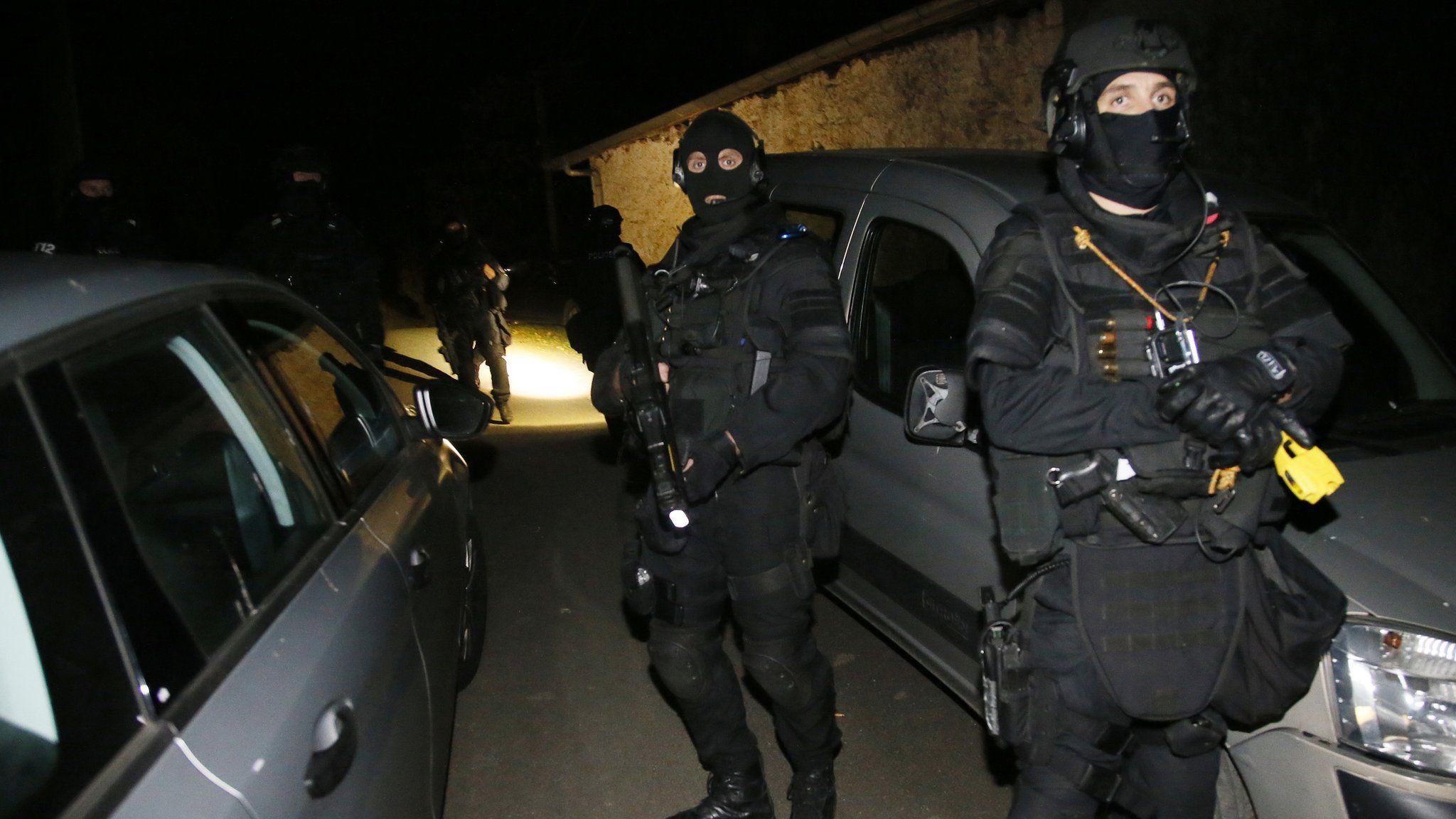 French police officers stand outside a house during a search operation in Louhossoa, south-western France, Friday, Dec 16, 2016