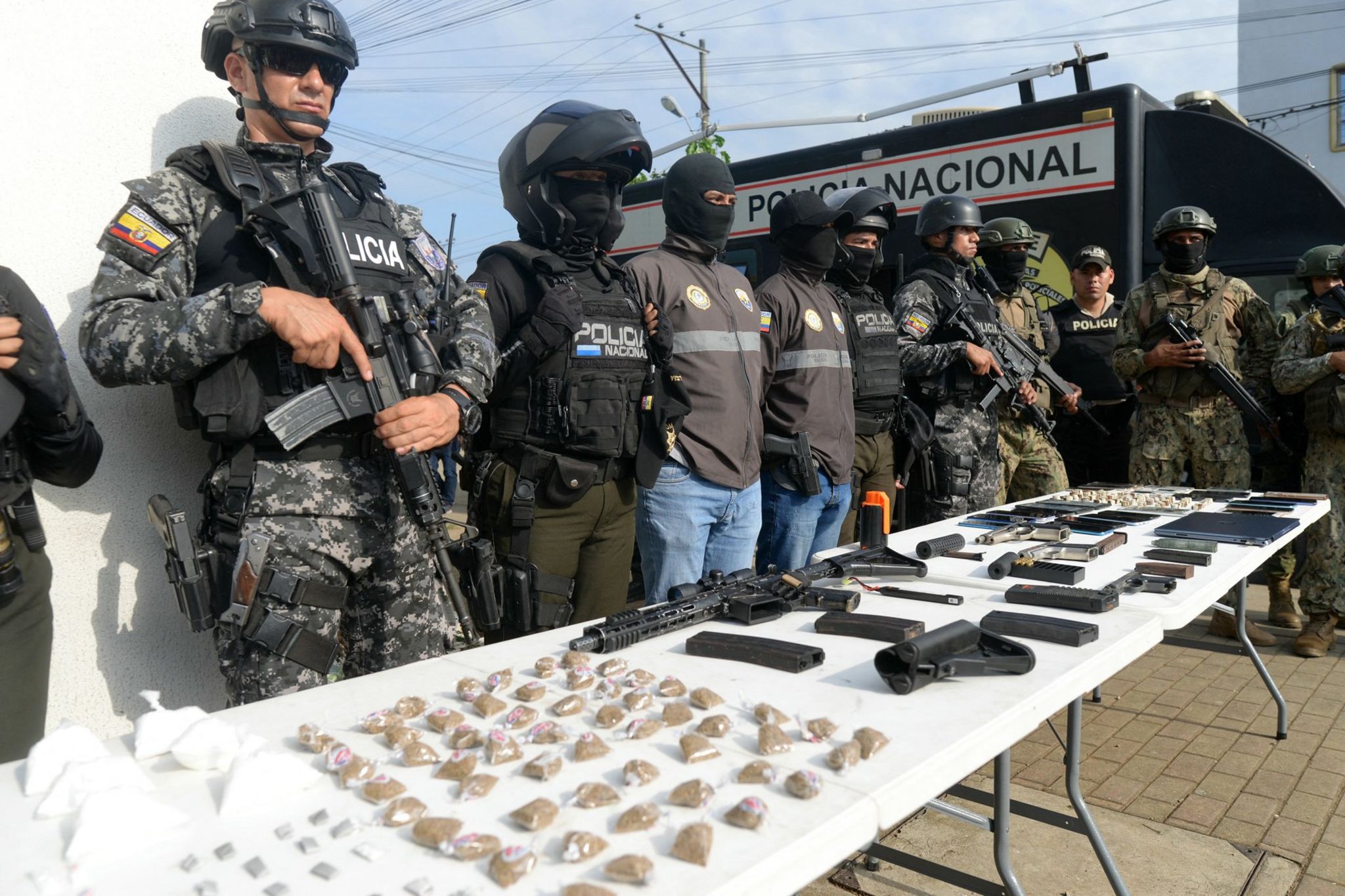 Policemen display seized drugs, weapons and phones after a joint operation with members of the military at the Socio Vivienda neighbourhood in Guayaquil, March 2024