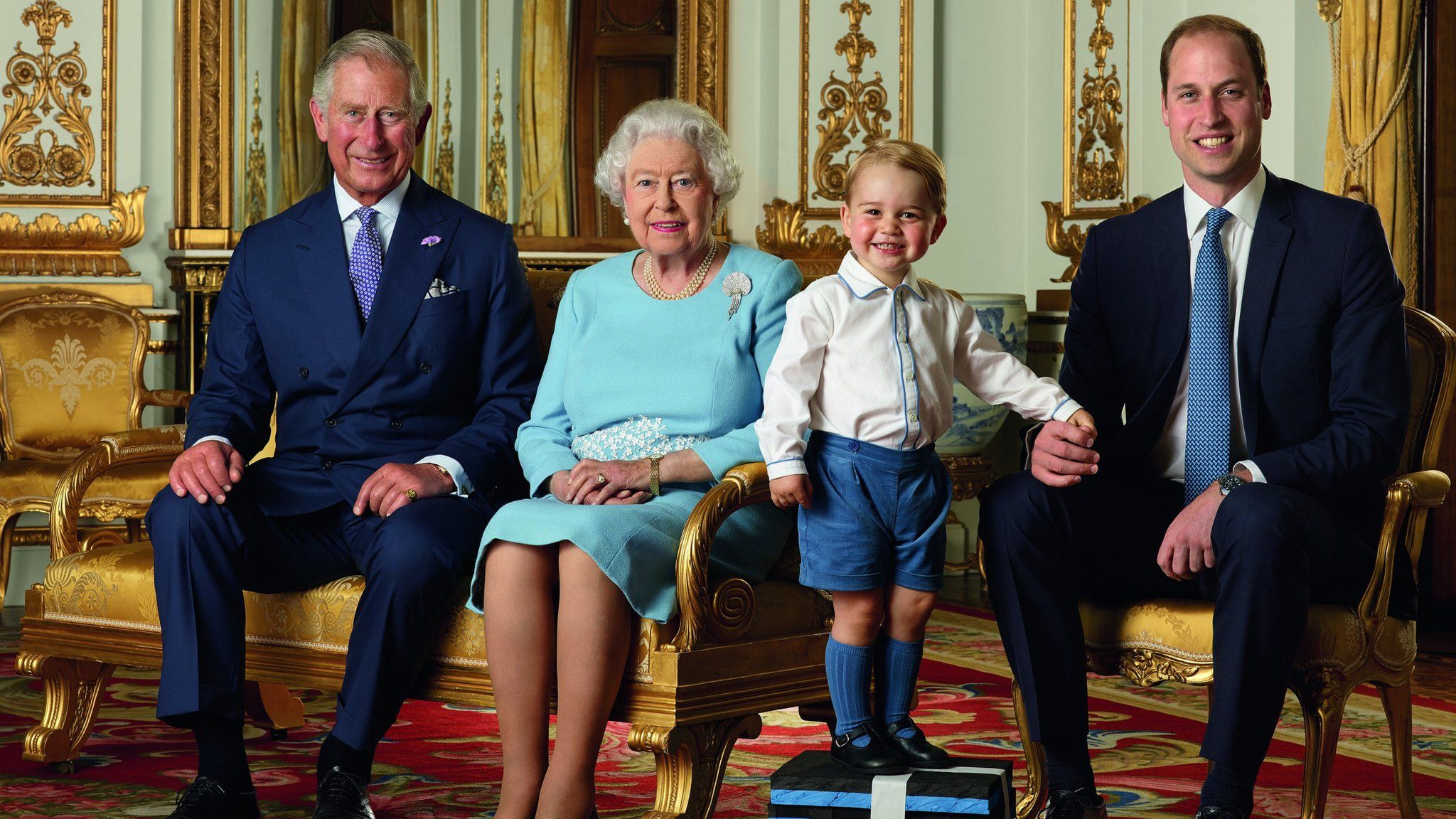 Prince George stands on foam blocks during a Royal Mail photo shoot for a stamp sheet to mark the Queen's 90th birthday. The sheet also features - Prince Charles, the Queen and Prince William