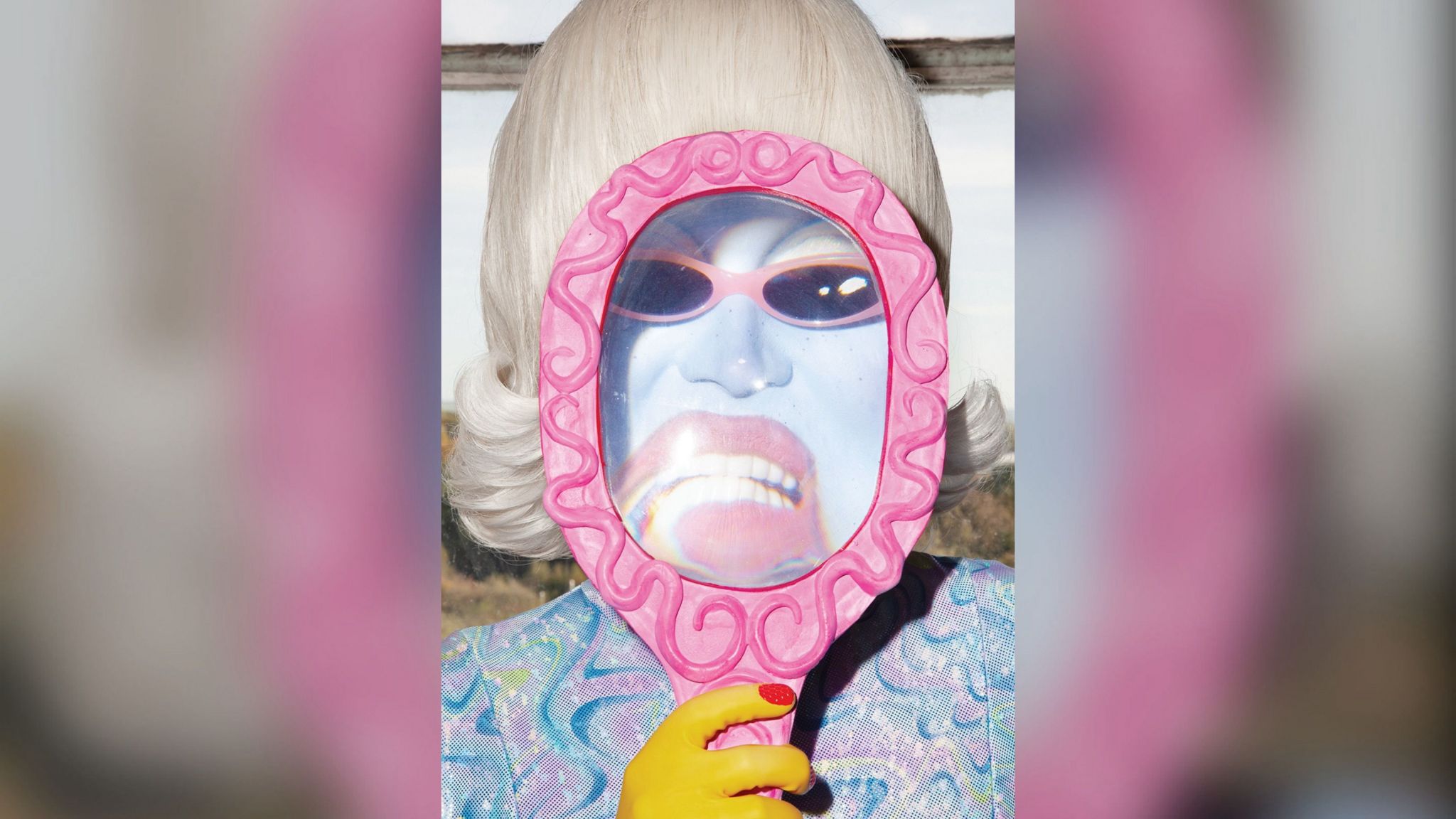 A drag queen behind a magnifying glass 