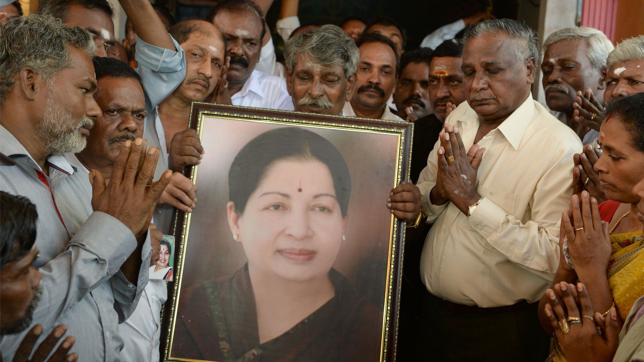 Supporters hold a photograph of Tamil Nadu state leader Jayalalithaa Jayaram