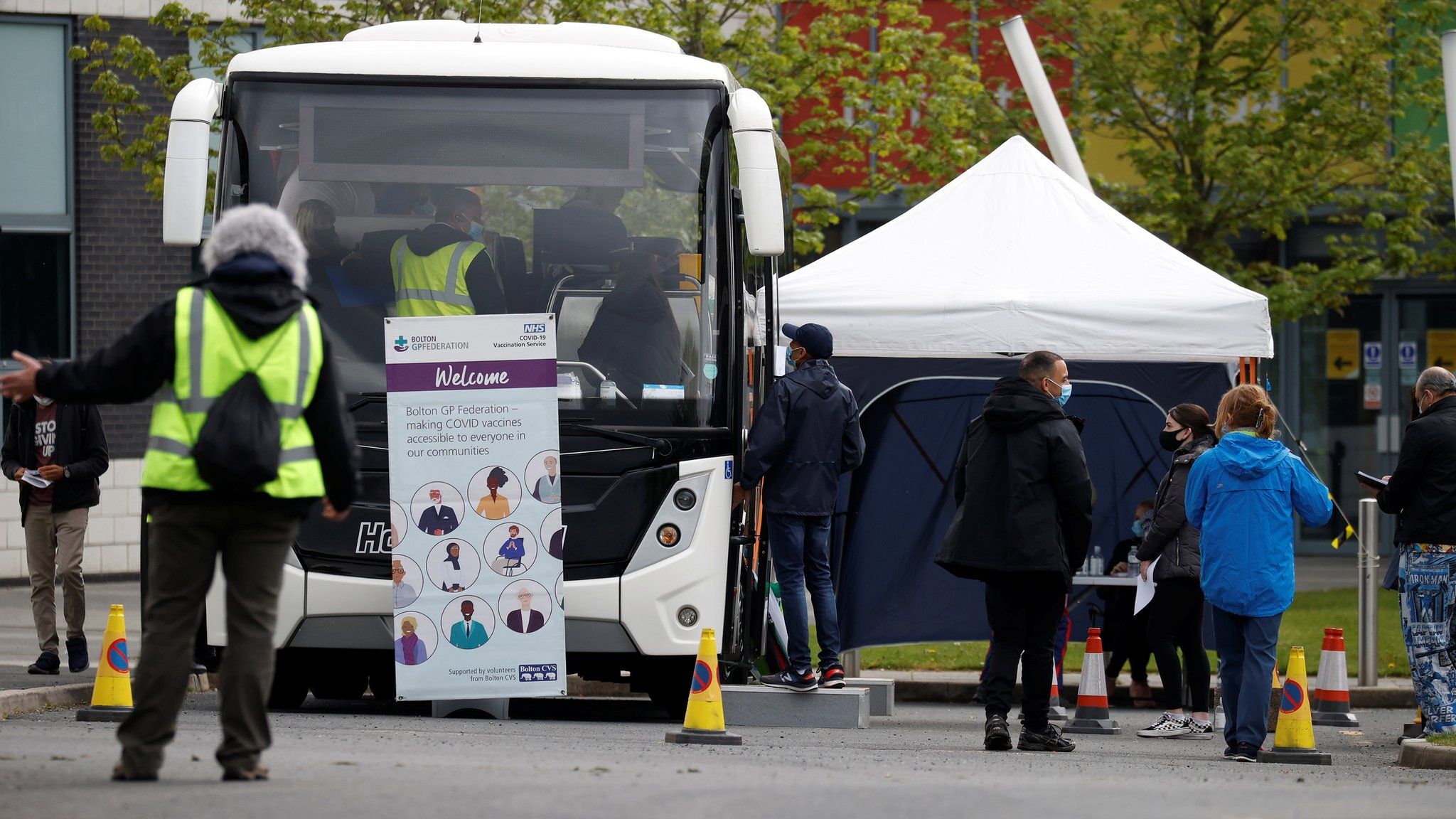 People line up outside a mobile vaccination centre in Bolton on Friday