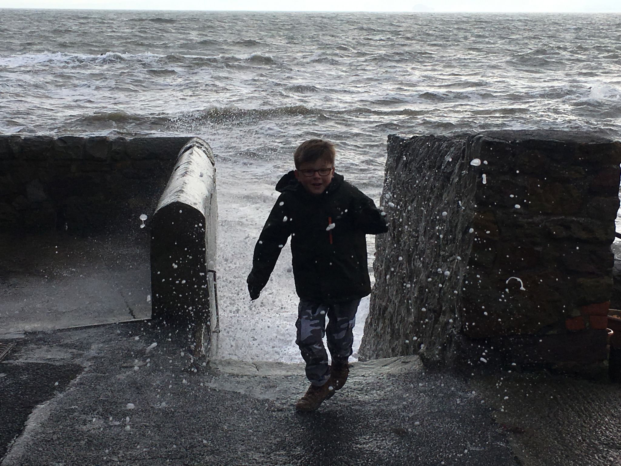 Boy running away from waves