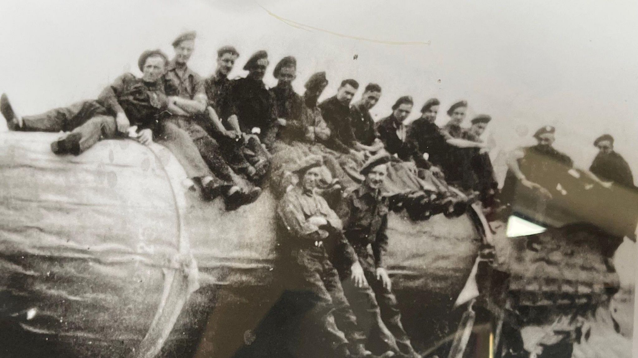 Mr Dalton, fifth from right, sits on a captured V2 rocket in wartime Germany