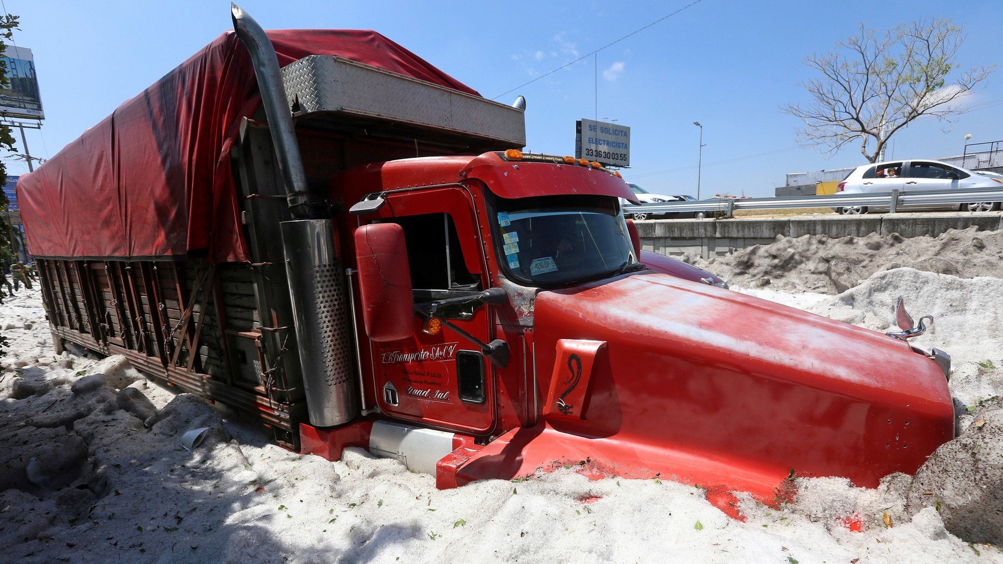 A truck is buried in ice after a heavy storm of rain and hail which affected some areas of the city Guadalajara