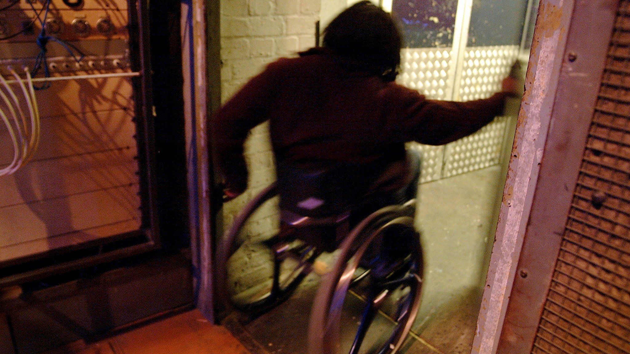 A man in a wheelchair going through a doorway