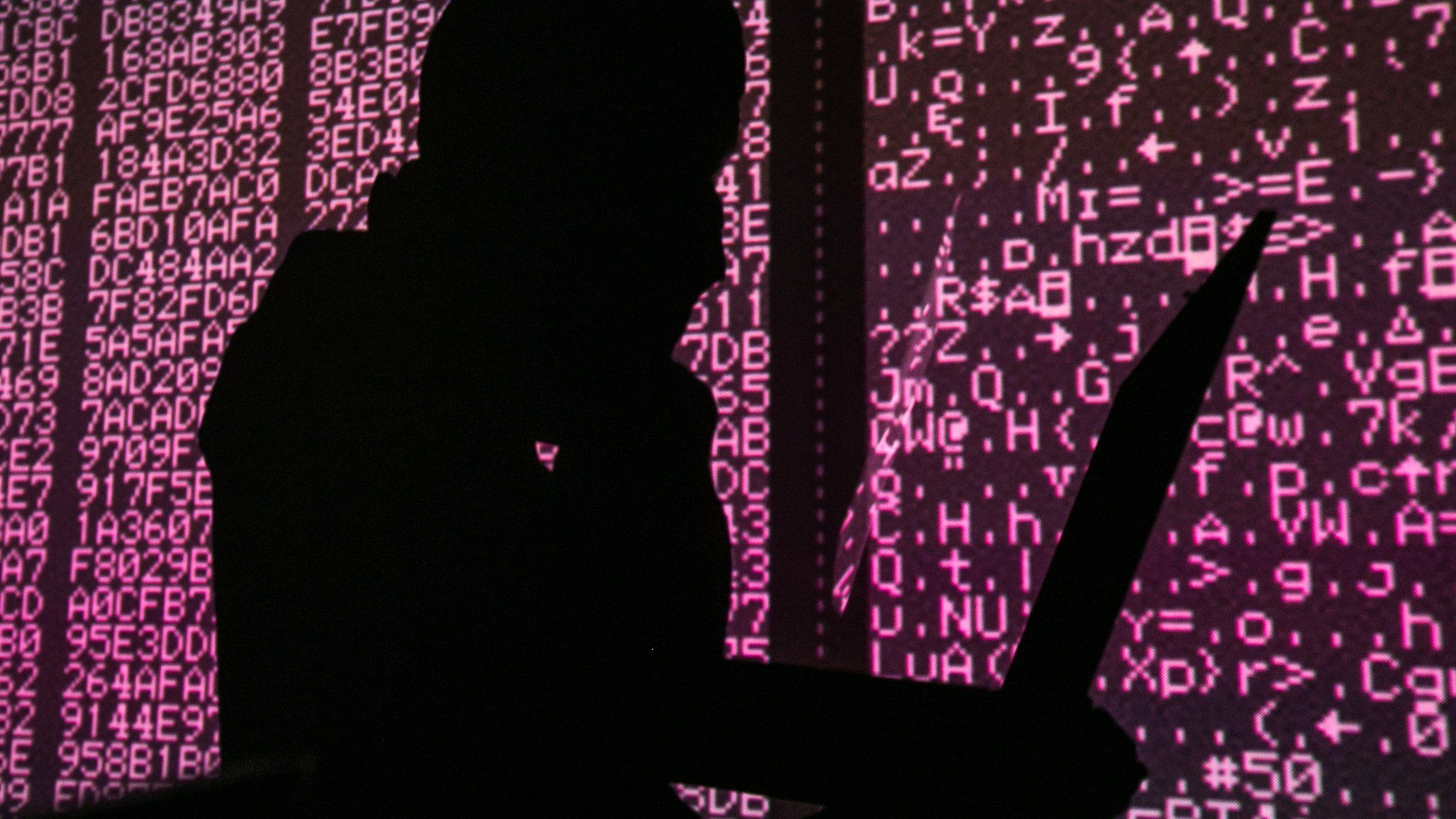 Silhouette of person on a computer