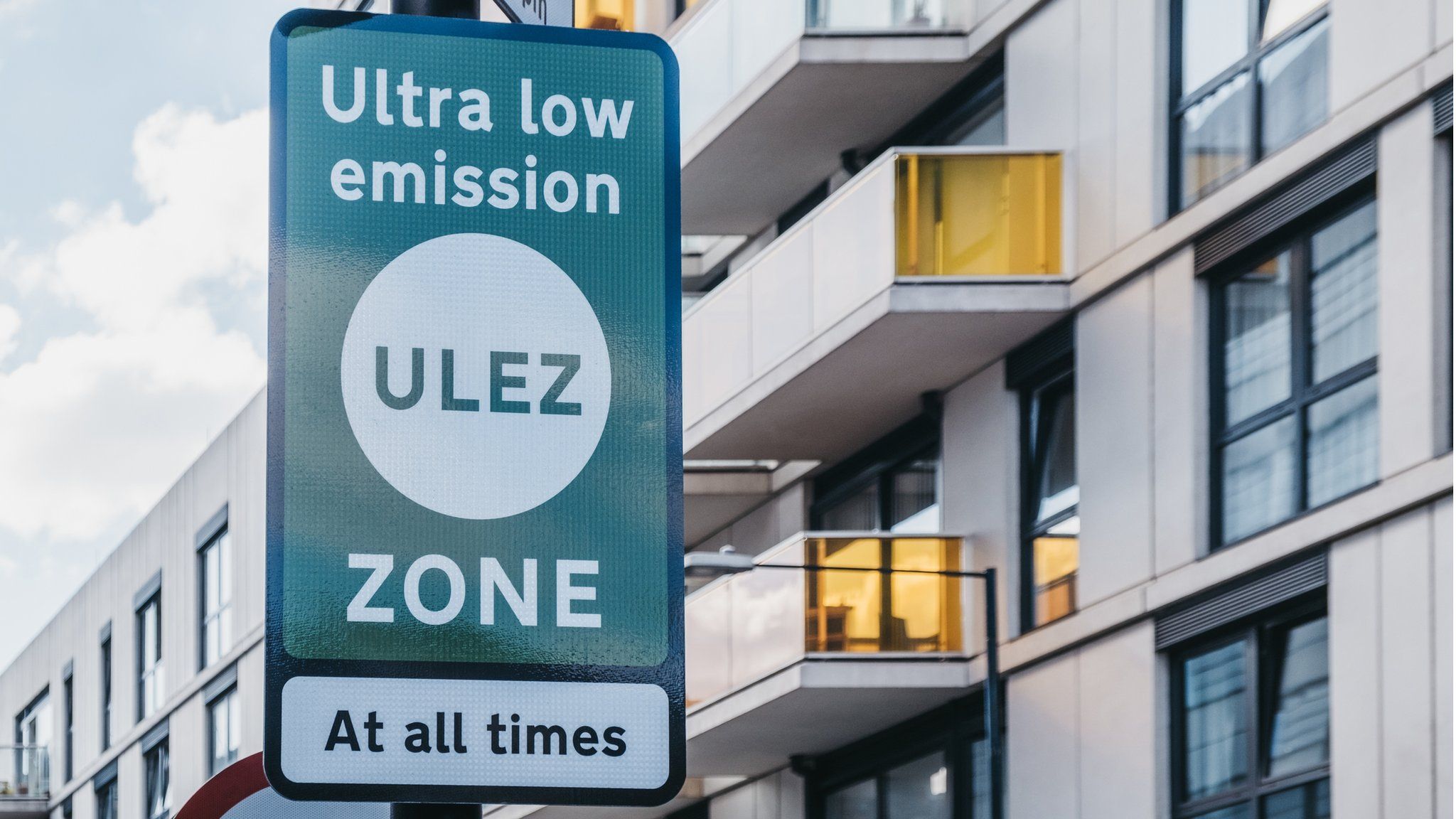 Green ULEZ sign in front of flats
