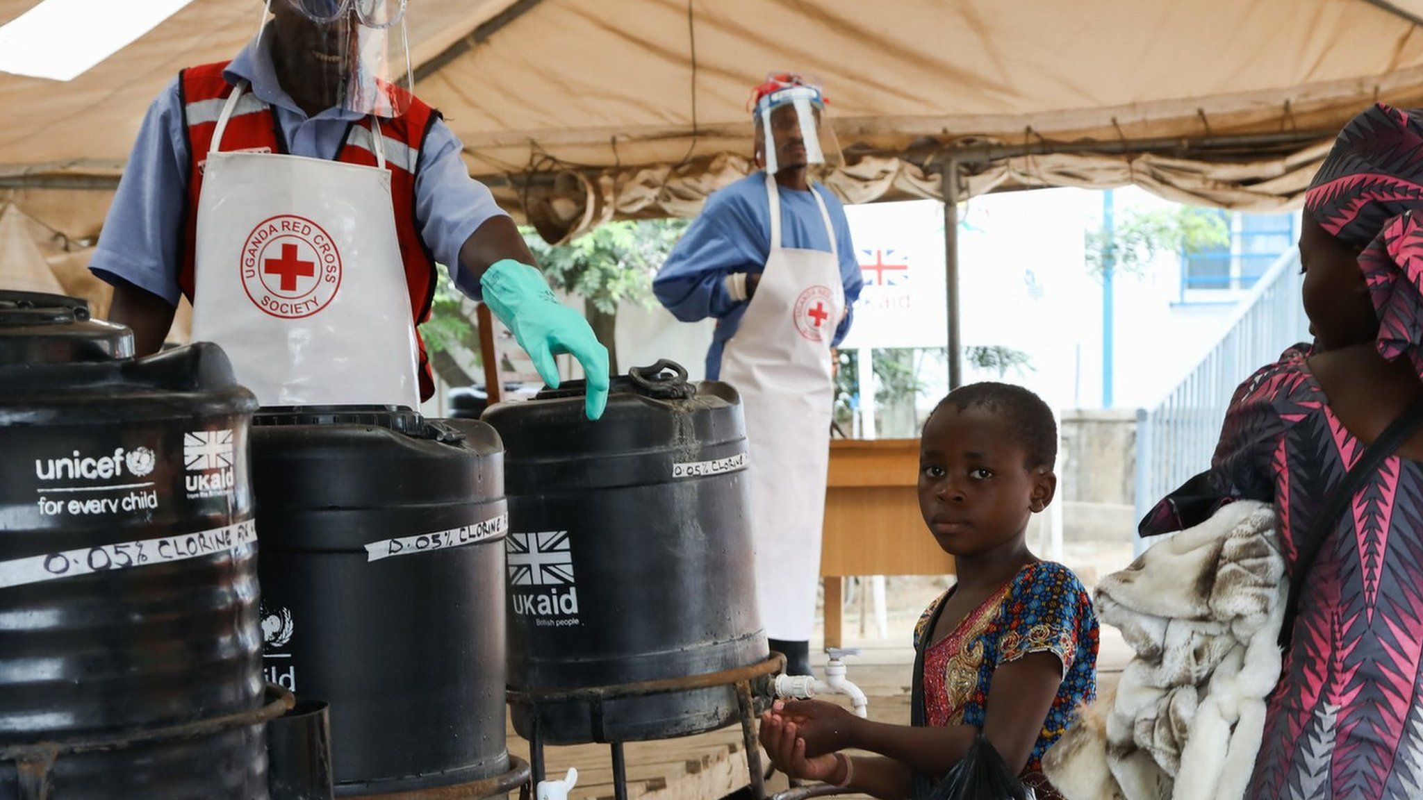 A young girl washes her hands in an Ebola prevention checkpoint supported by UK aid at a Ugandan border crossing point with the DRC, August 2019