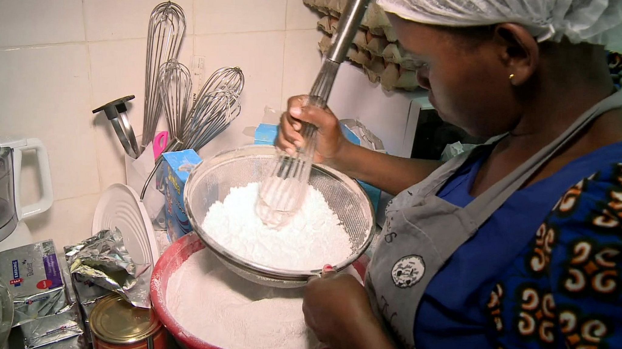 woman sieving sugar in bowl
