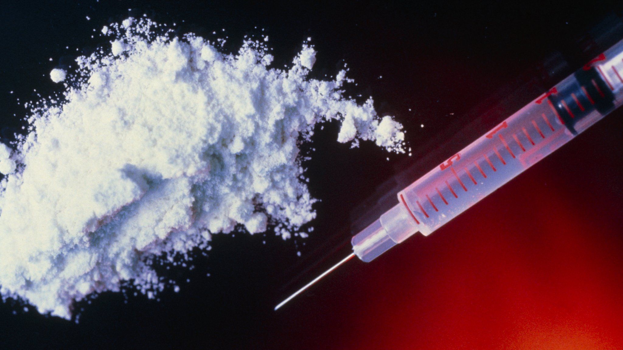 A hypodermic syringe and the drug heroin (file image)