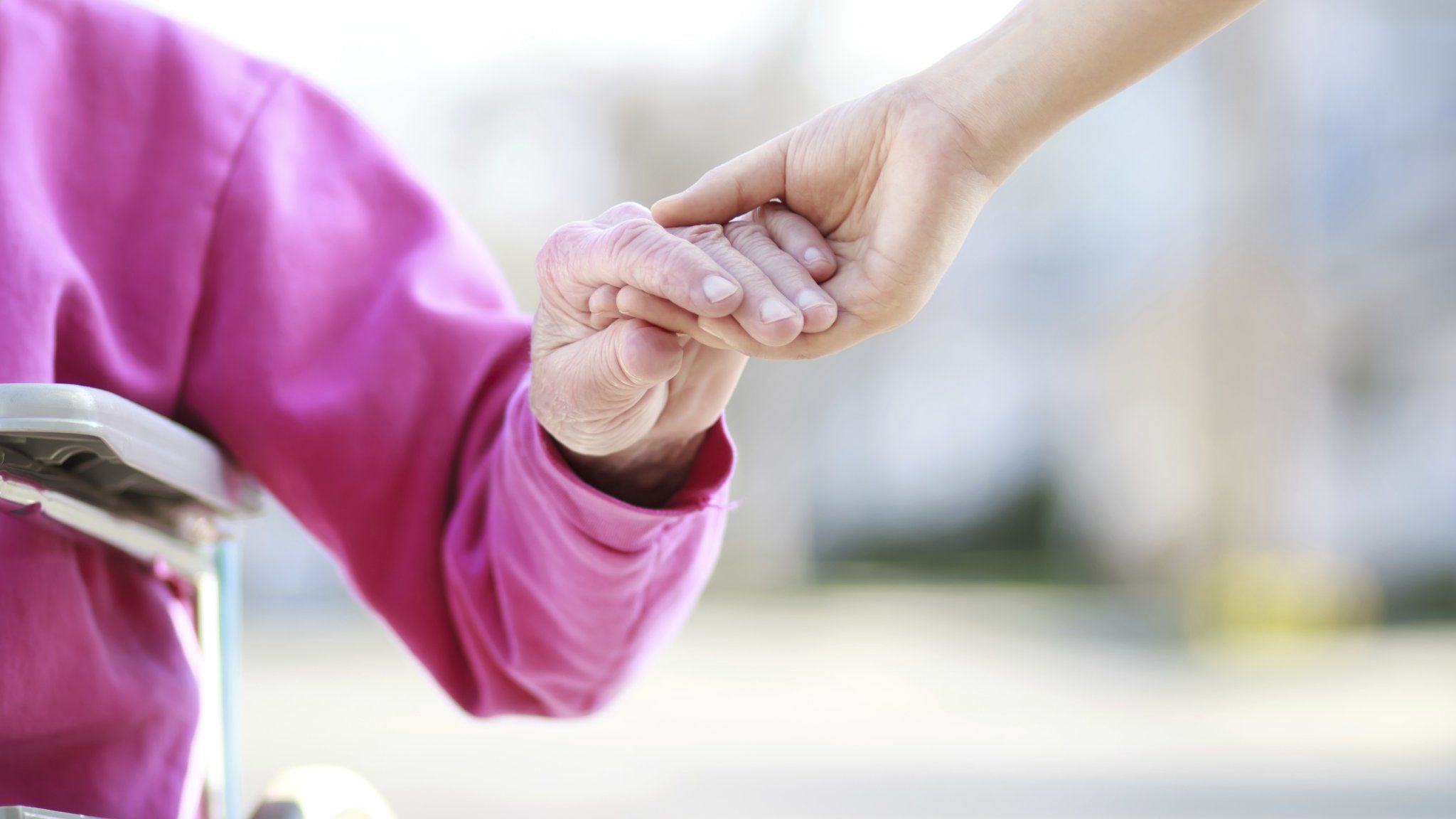 Elderly person's hand being held