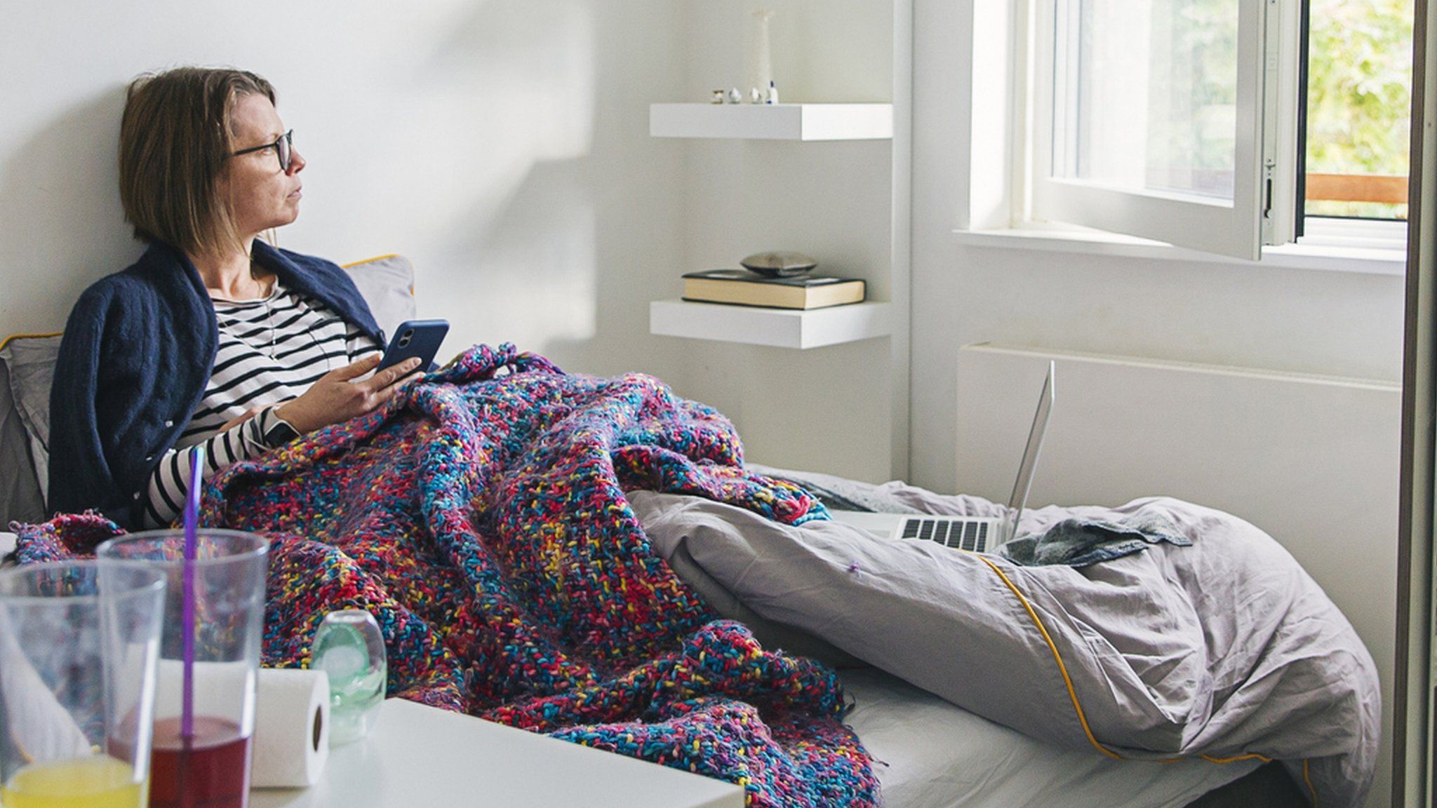 A woman looking at her phone in bed