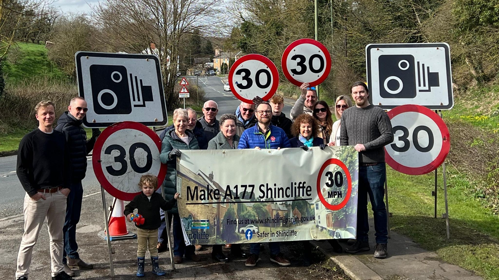 Members of the Safer in Shincliffe campaign group holding  a banner by the road