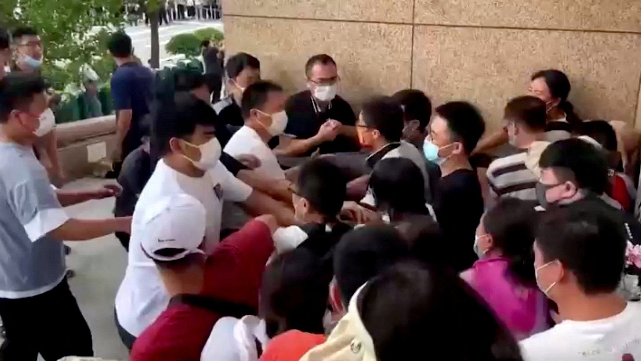 Security personnel scuffle with protestors in Zhengzhou.