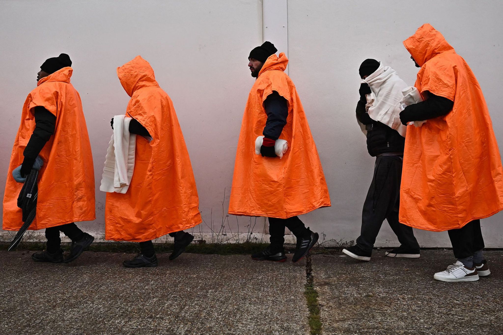 Migrants standing in a queue waiting to be processed in Kent.