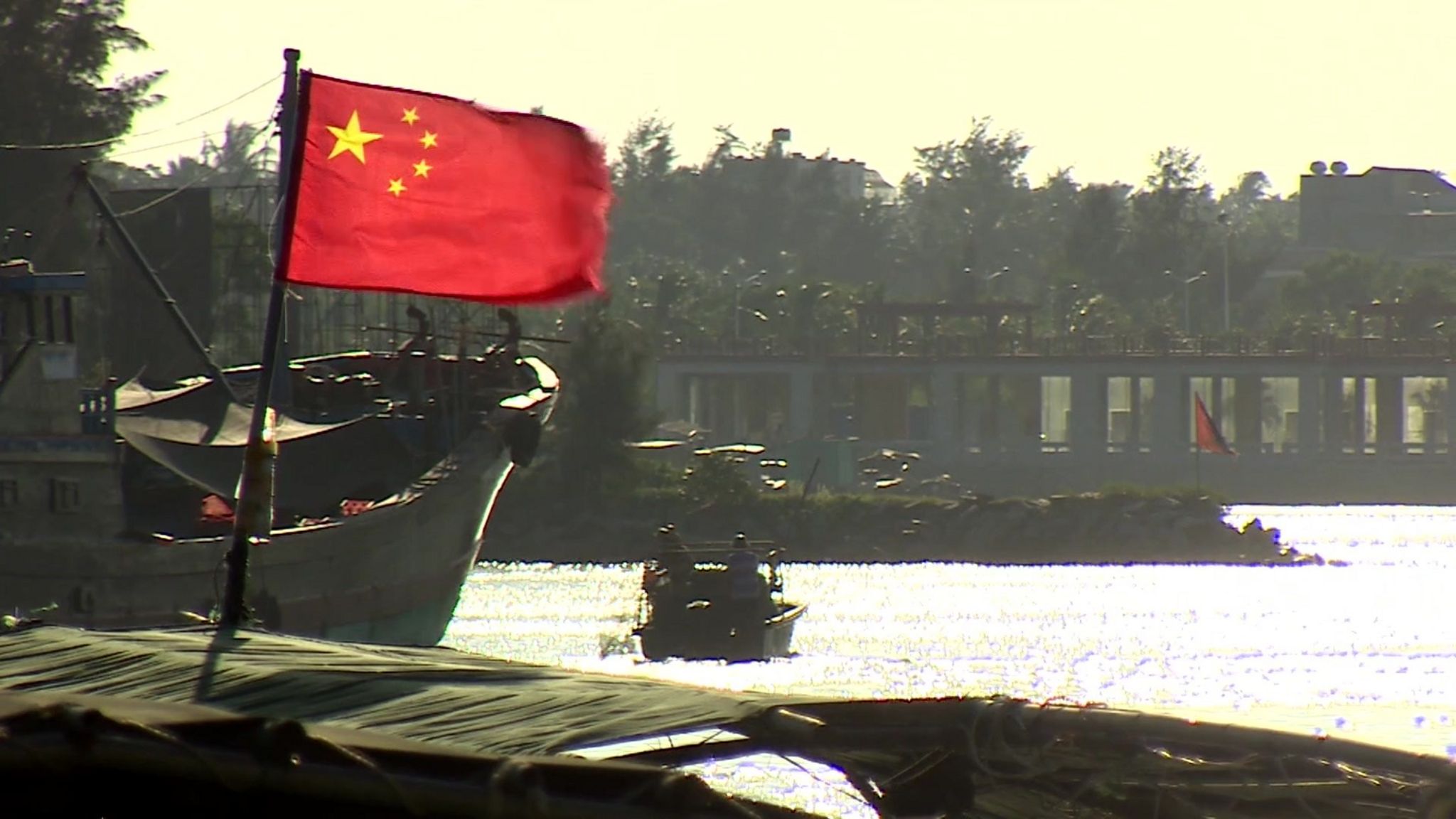 Chinese flag flies from a fishing boat on the coast in Hainan.