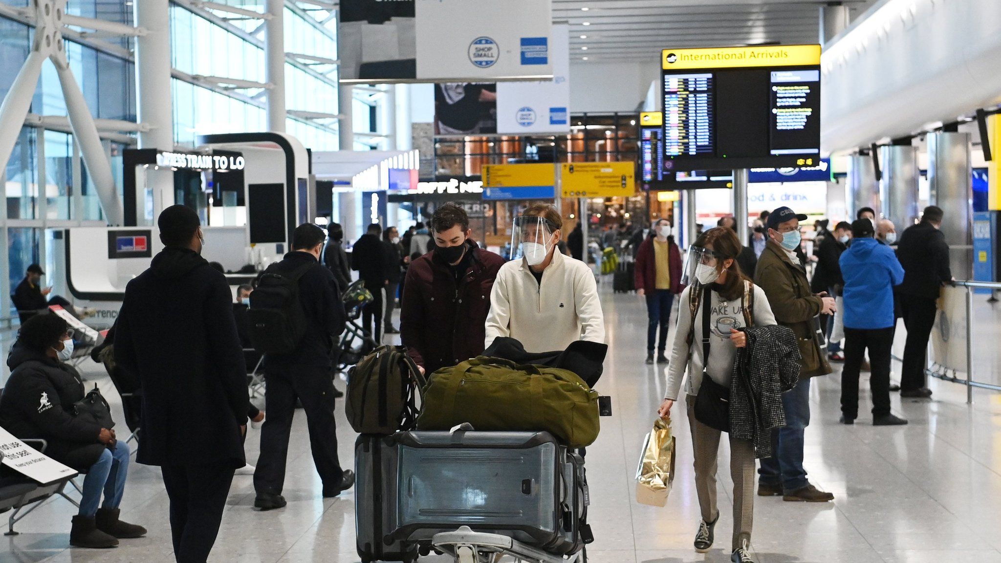 Travellers in the international arrival area of Heathrow Airport, near London
