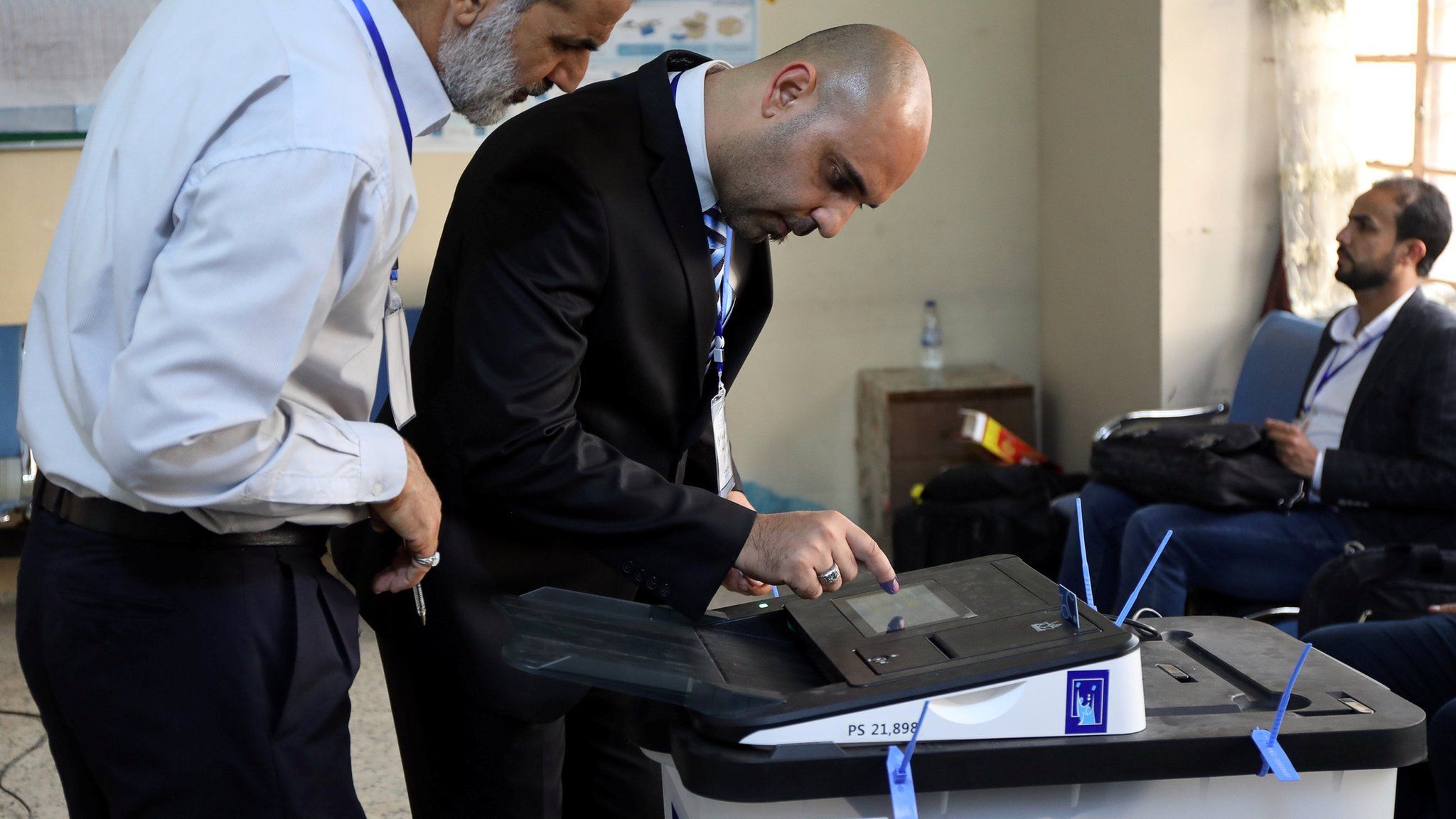 Iraqi election officials check an electronic vote-counting machine in Baghdad on 12 May 2018